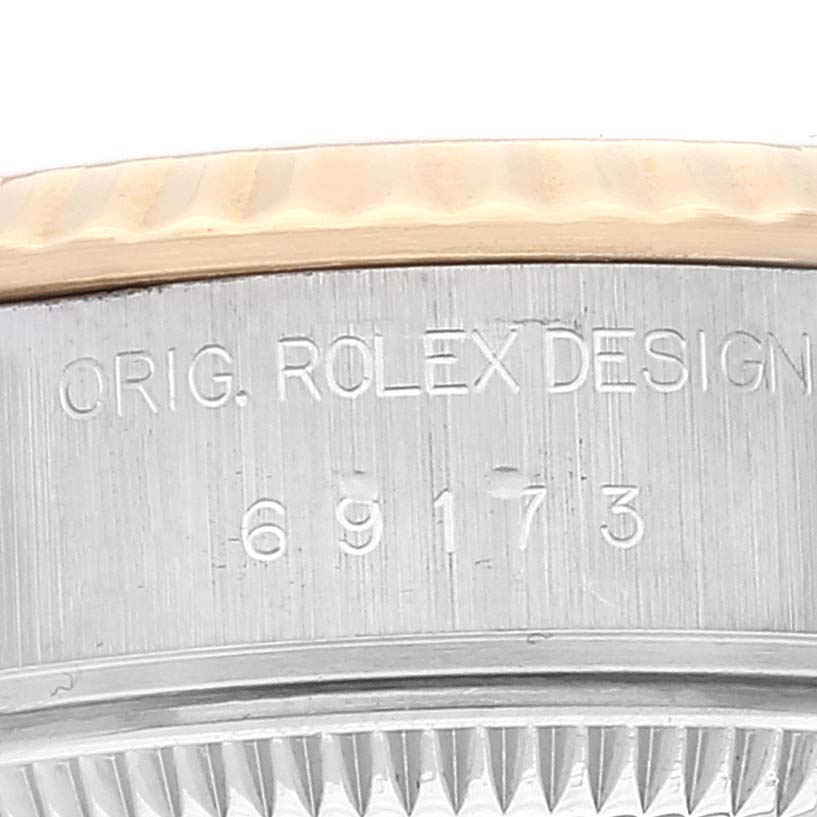 The image shows a close-up of the engraved case side and bezel edge of a Rolex Datejust 69173 Women's Steel and Gold (two tone) Champagne Dial 69173 Women's Steel and Gold (two tone) Champagne Dial watch.