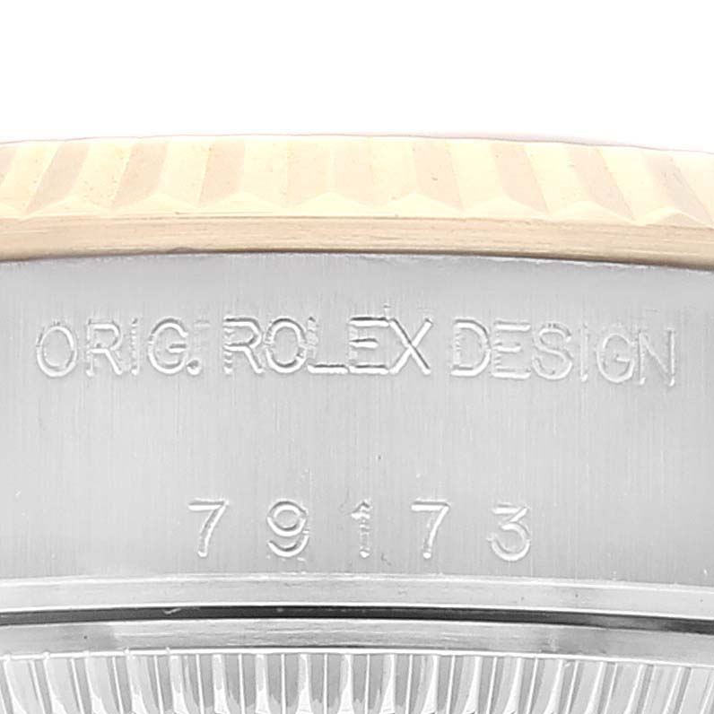 This close-up image shows the side casing of a Rolex Datejust 79173 Women's Steel and Gold (two tone) Champagne Dial 79173 Women's Steel and Gold (two tone) Champagne Dial model, displaying the engraving "ORIG. ROLEX DESIGN" and the model number 79173.