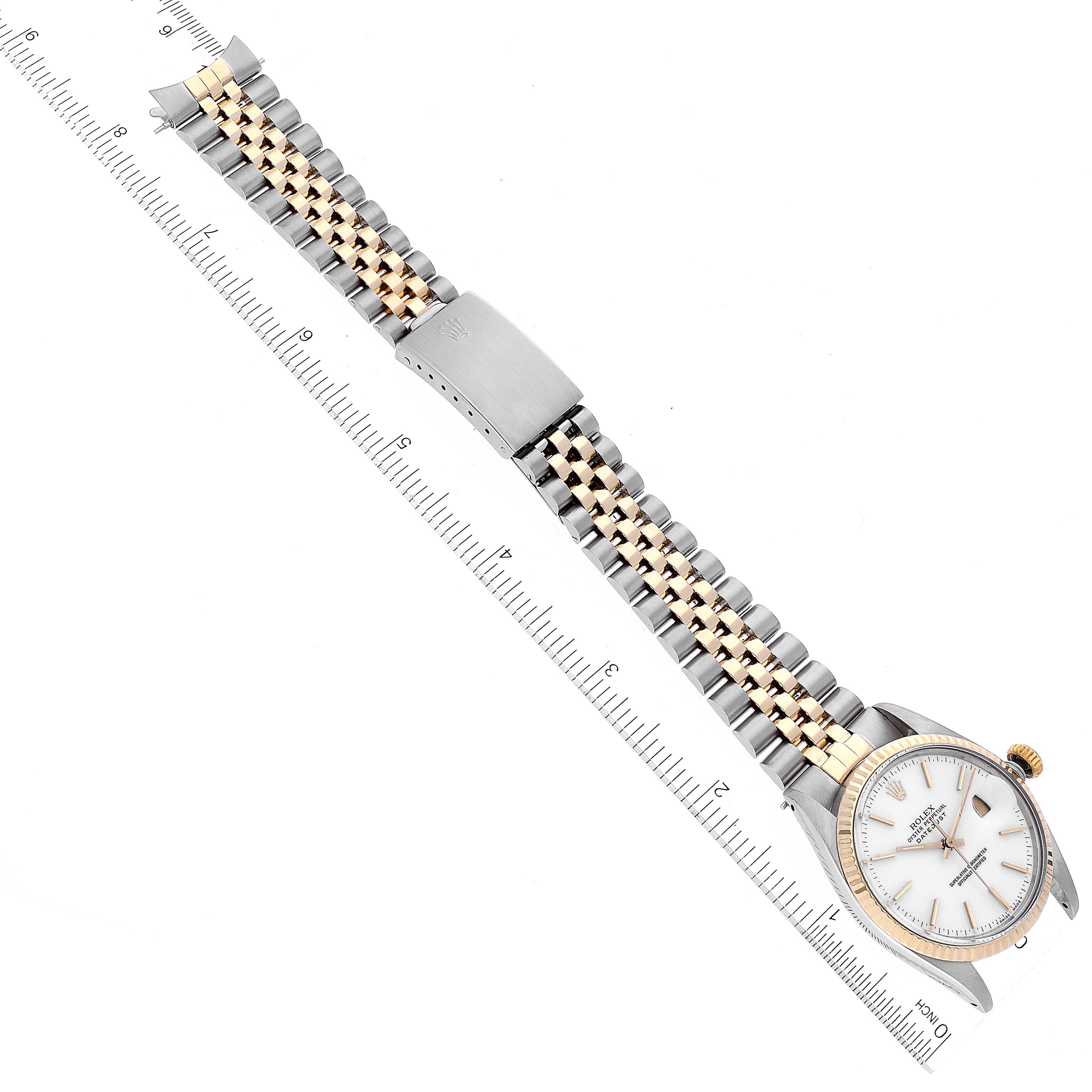 This image shows the Rolex Vintage Collection 16013 Men's Steel and Gold (two tone) White Dial 16013 Men's Steel and Gold (two tone) White Dial watch laid flat with its face up and band extended, alongside a ruler for scale.