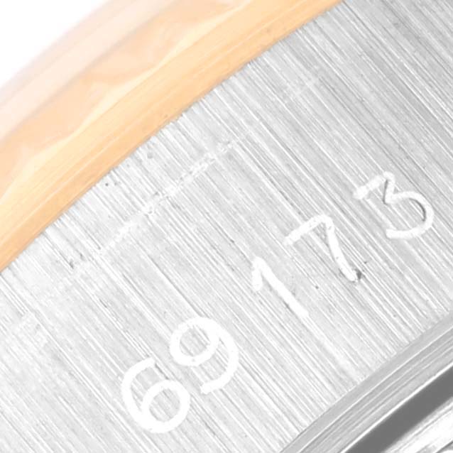 This close-up image shows the serial number engraving on the side of a Rolex Datejust 69173 Women's Steel and Gold (two tone) White Dial 69173 Women's Steel and Gold (two tone) White Dial watch.