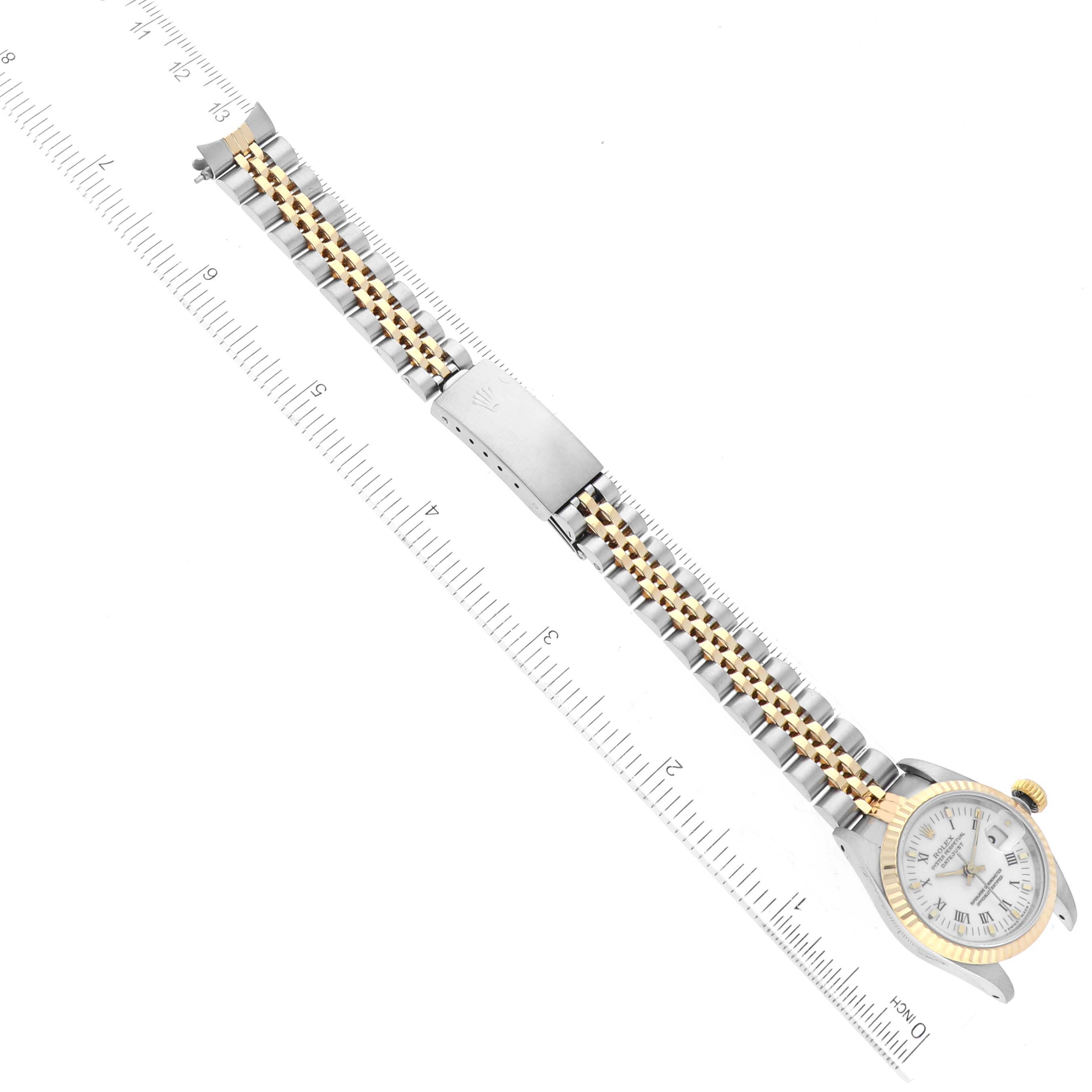 The Rolex Datejust 69173 Women's Steel and Gold (two tone) White Dial 69173 Women's Steel and Gold (two tone) White Dial watch is shown from a top-down angle, displaying the dial, case, and bracelet placed next to a measuring ruler.