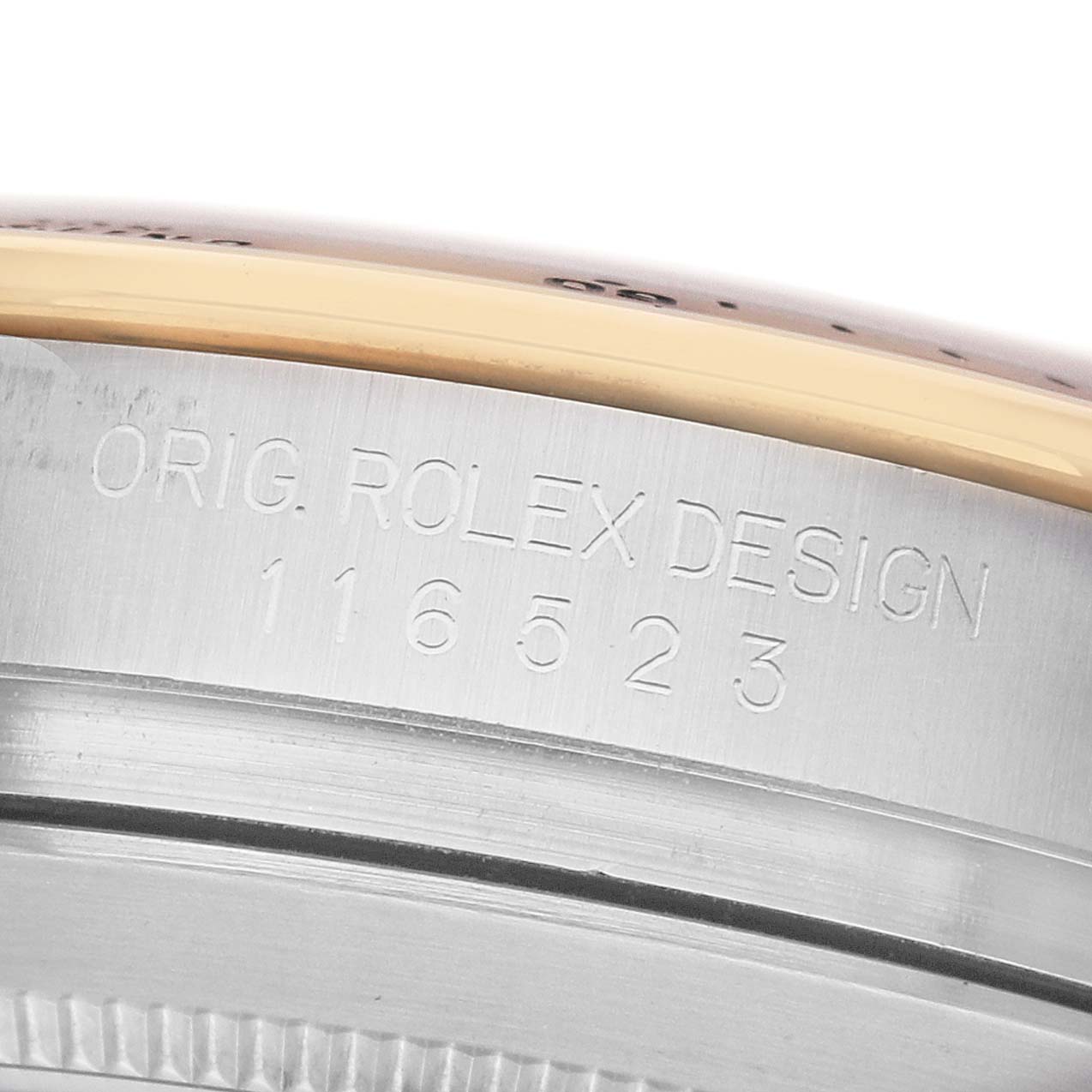 The image shows a close-up of the Rolex Daytona 116523 Men's Steel and Gold (two tone) Yellow Dial model's case side, displaying the engraved "ORIG. ROLEX DESIGN 116523".