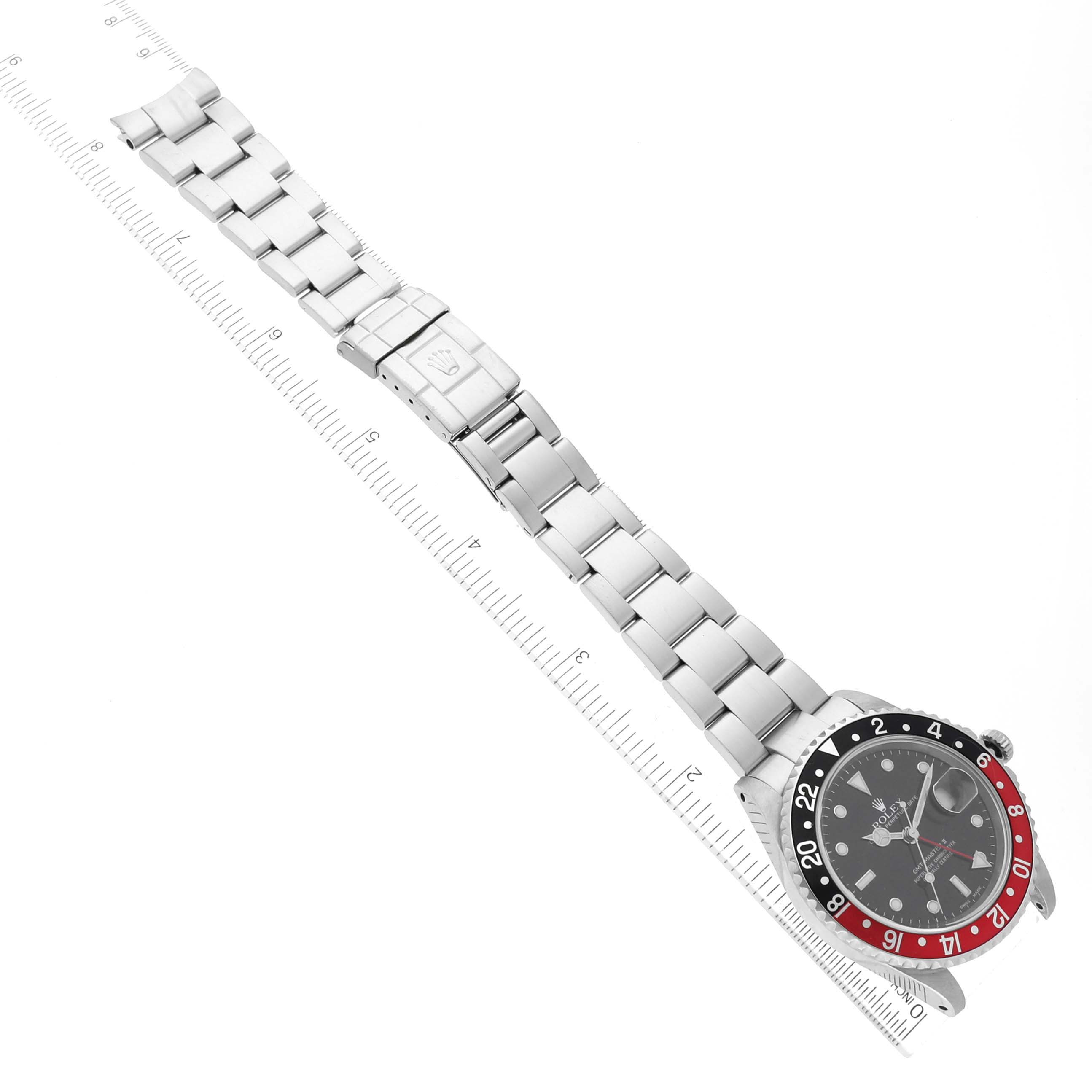 The image shows a top-down view of a Rolex GMT-Master 16710 Men
s Stainless Steel Black Dial 16710 Men
s Stainless Steel Black Dial watch with its bracelet fully extended next to a ruler.