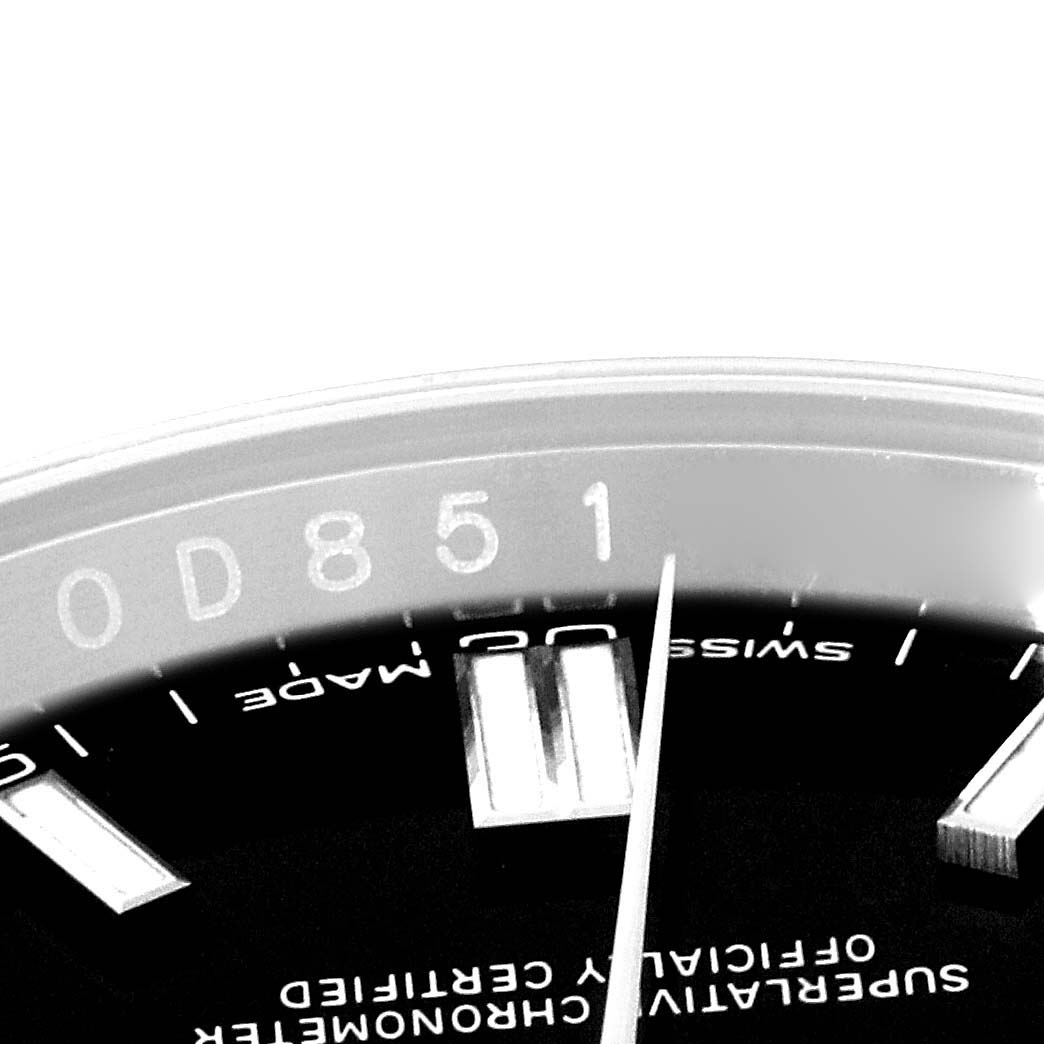 This close-up image shows the partial view of the dial and bezel of the Rolex Oyster Perpetual 116000 Men's Stainless Steel Black Dial 116000 Men's Stainless Steel Black Dial watch.