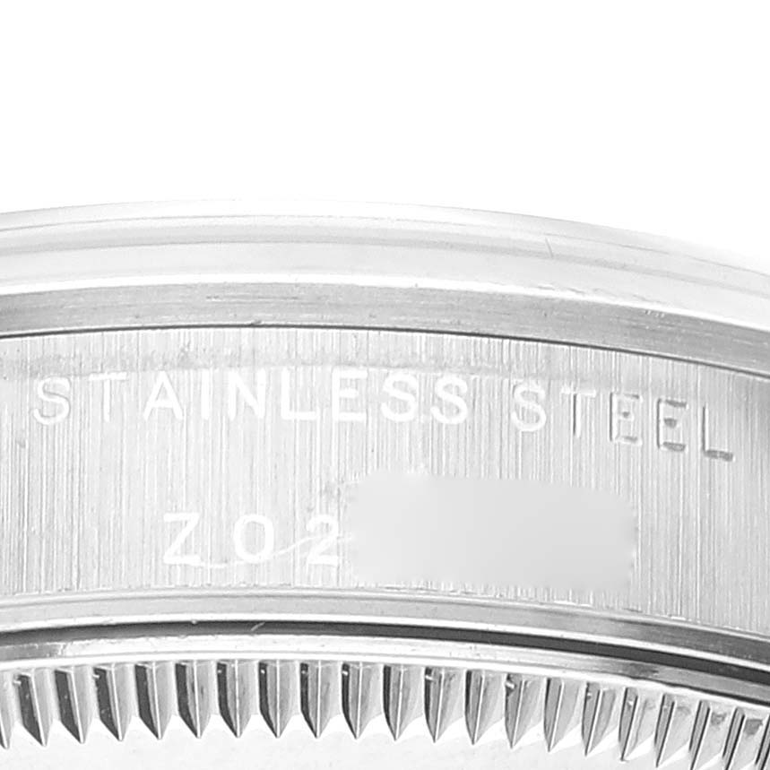 The image shows a close-up of the back case of a Mid-Size Rolex watch, highlighting the "STAINLESS STEEL" engraving.