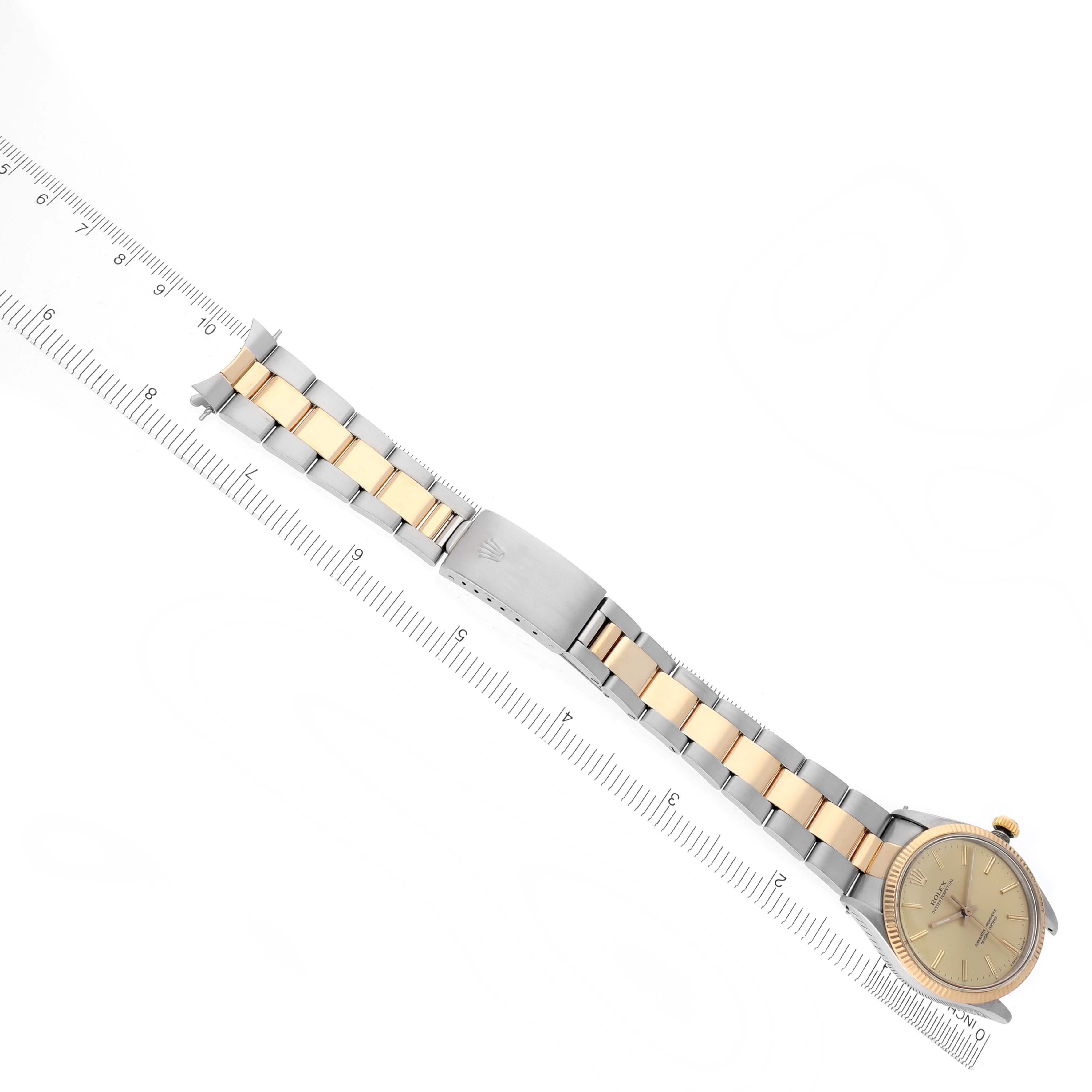 The Rolex Vintage Collection 1005 Men's Steel and Gold (two tone) Champagne Dial 1005 Men's Steel and Gold (two tone) Champagne Dial watch is shown from a top-down angle, displaying the bracelet and clasp alongside a ruler for scale.