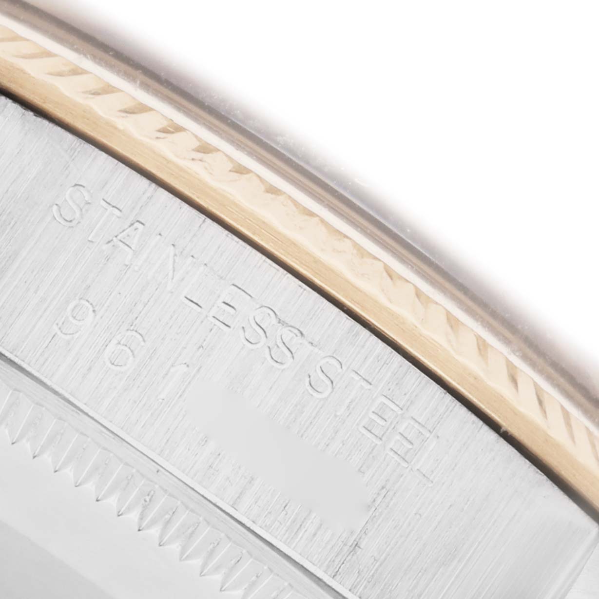 The image shows the edge of the case back of the Rolex Vintage Collection 1005 Men's Steel and Gold (two tone) Champagne Dial 1005 Men's Steel and Gold (two tone) Champagne Dial watch, highlighting the "STAINLESS STEEL" engraving.