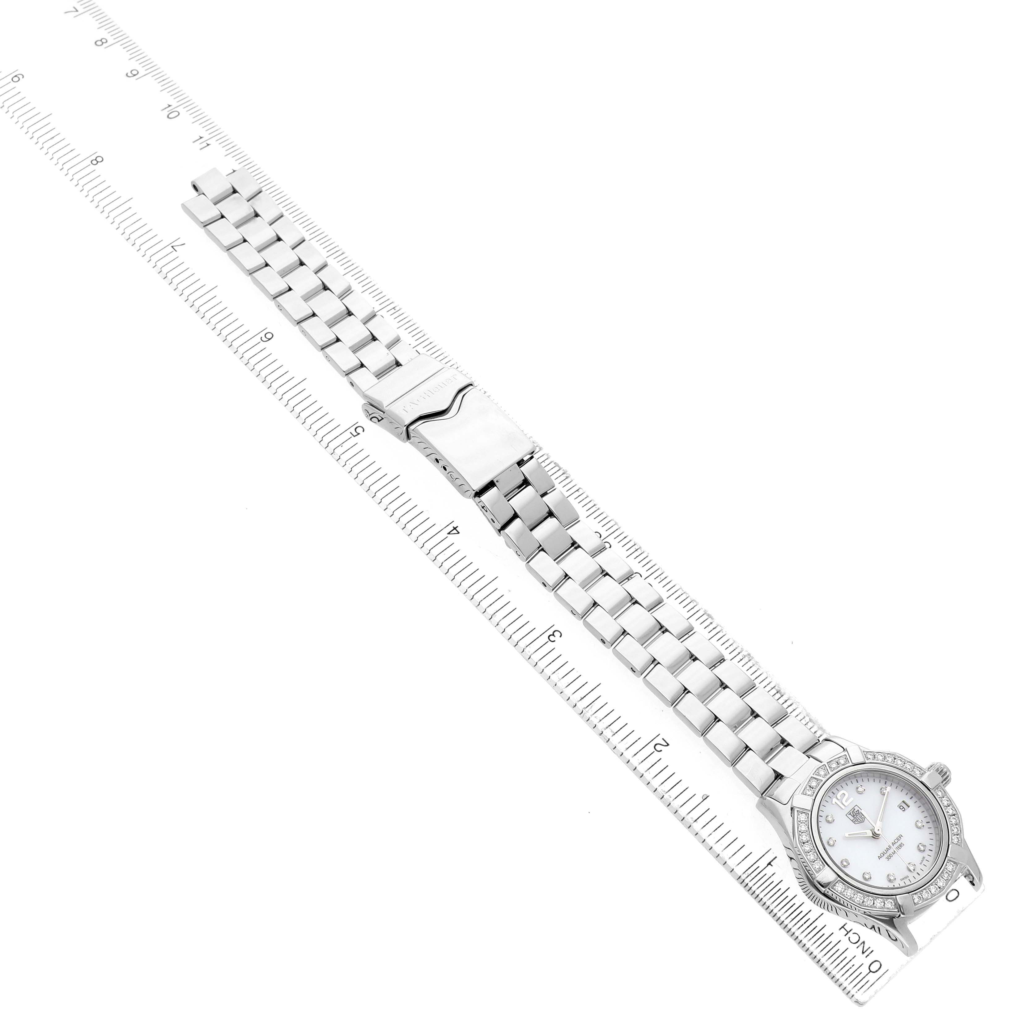 The Tag Heuer Aquaracer WAF1416 Women's Stainless Steel Mother of Pearl Dial watch is shown from above, displaying its full bracelet and watch face alongside a ruler.