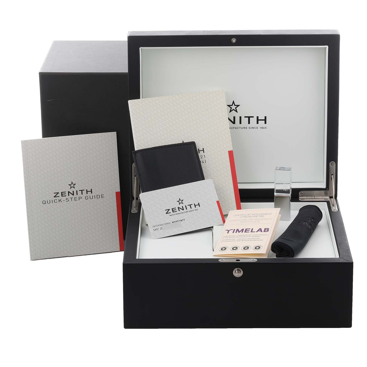 The image shows the Zenith El Primero 95.9002.9004/78.R584 Men
s Titanium Transparent Dial 95.9002.9004/78.R584 Men
s Titanium Transparent Dial watch box and accessories, including manuals and a card, from a front angle.