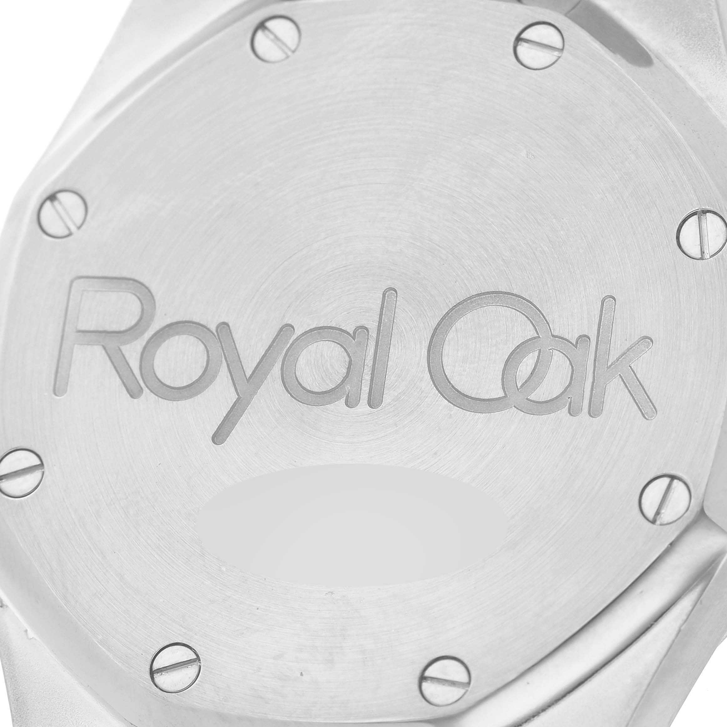 The image shows the case back of a Royal Oak watch by Audemars Piguet, highlighting the "Royal Oak" engraving and screws.