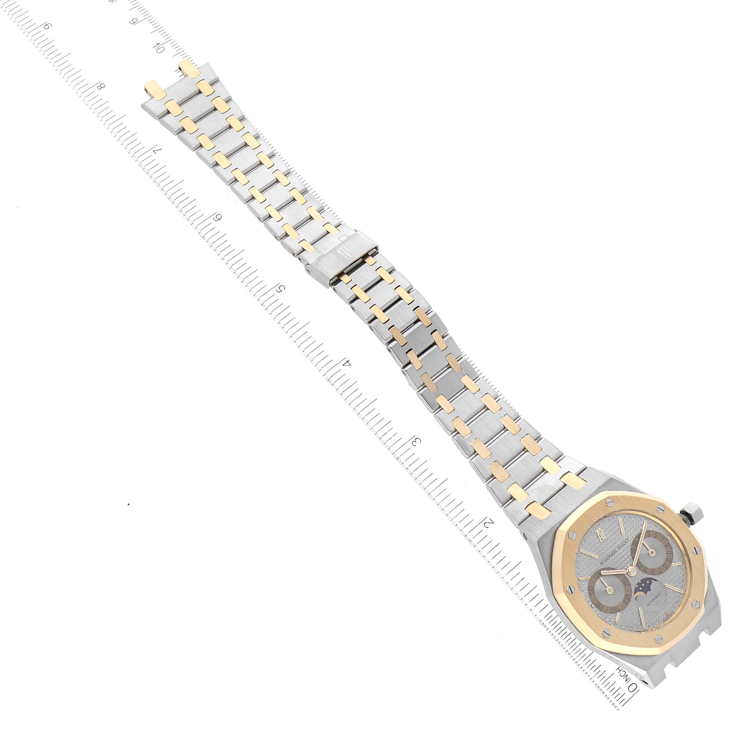 The image shows a top-down view of an Audemars Piguet Royal Oak 25594SA Men's Steel and Gold (two tone) Silver Dial 25594SA Men's Steel and Gold (two tone) Silver Dial watch with a two-tone metal bracelet and a ruler for scale.
