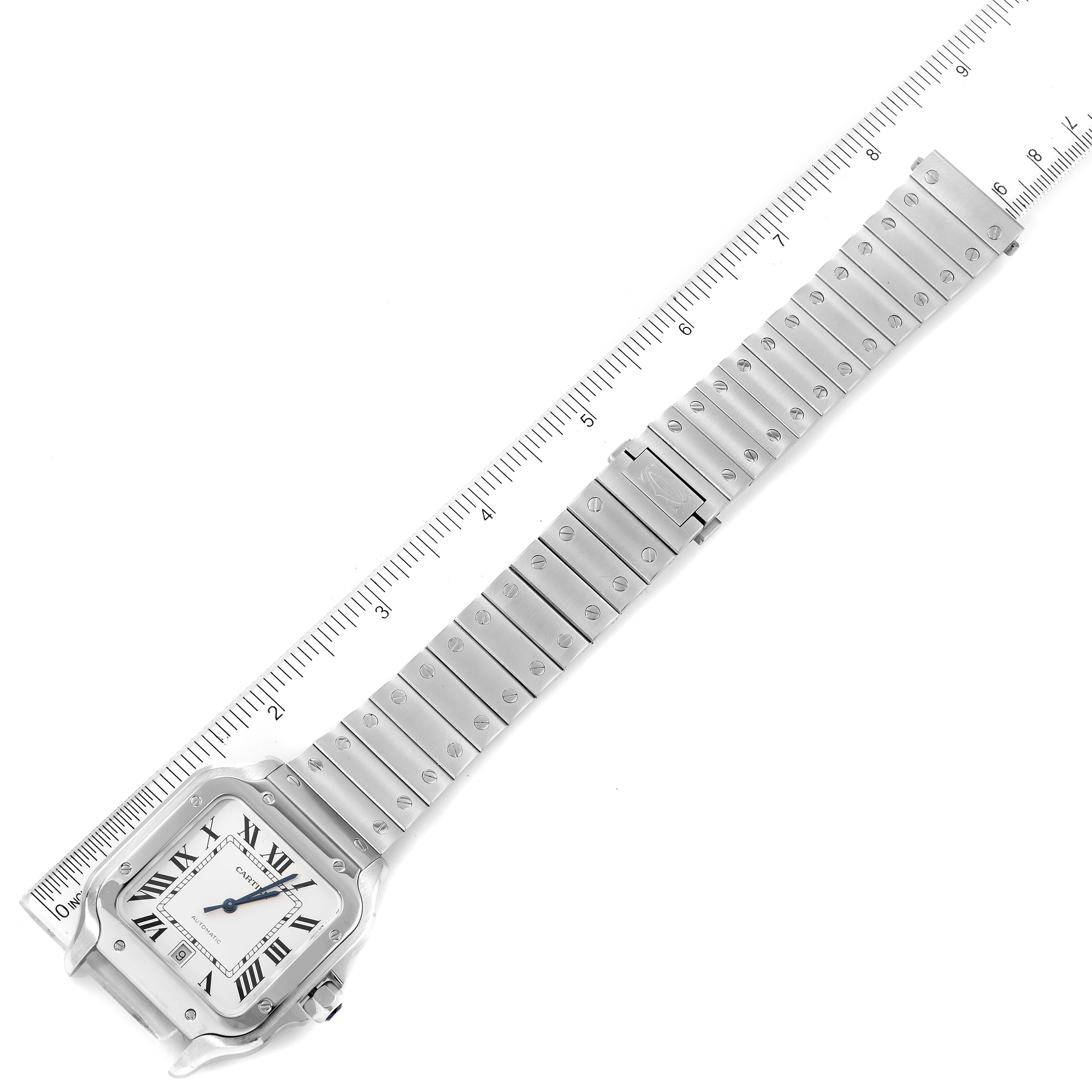The image shows an overhead view of a Cartier Santos WSSA0018 Men's Stainless Steel Silver Dial WSSA0018 Men's Stainless Steel Silver Dial watch and its bracelet next to a measuring ruler.