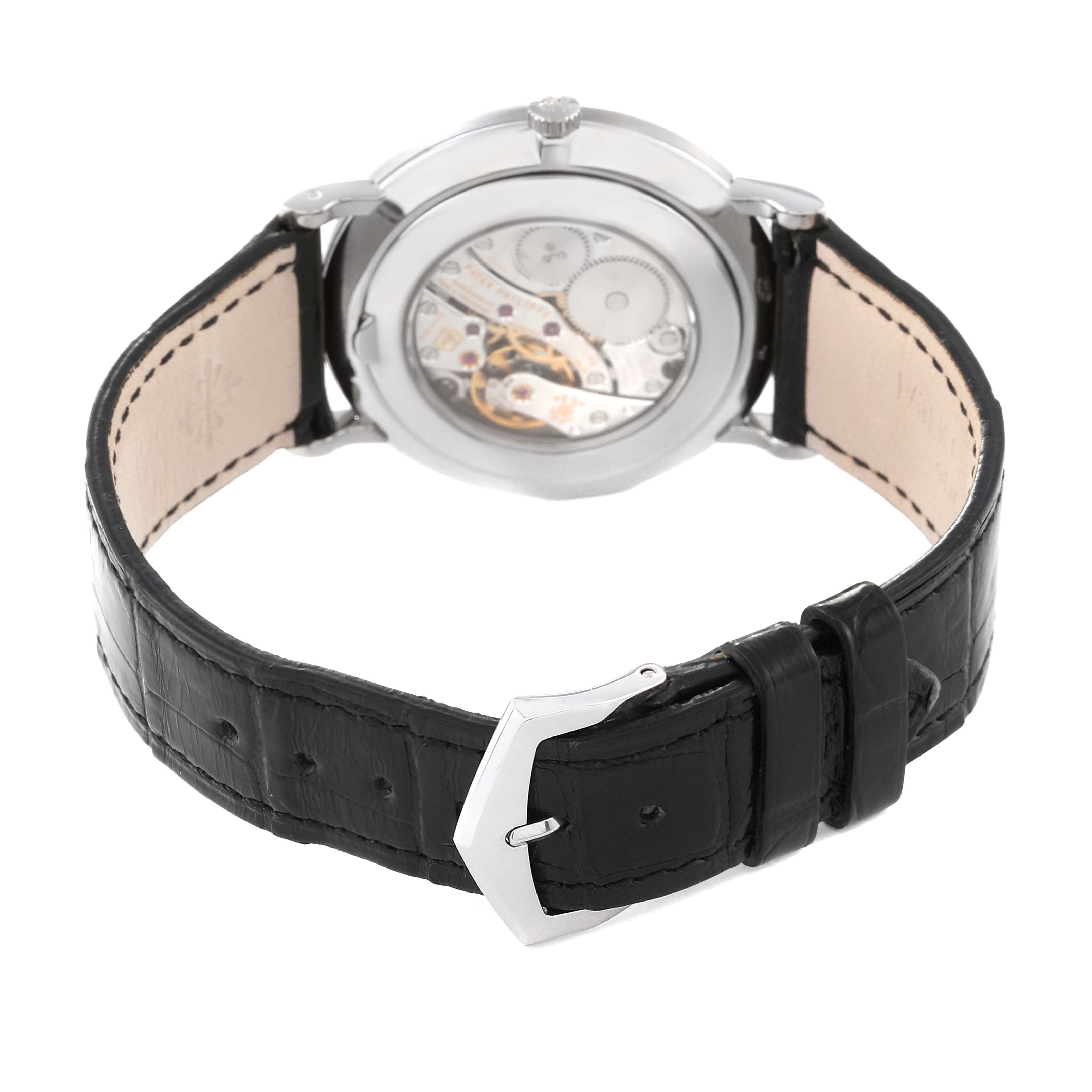 The image shows the back view of a Calatrava model by Patek Philippe, displaying its movement and black leather strap.