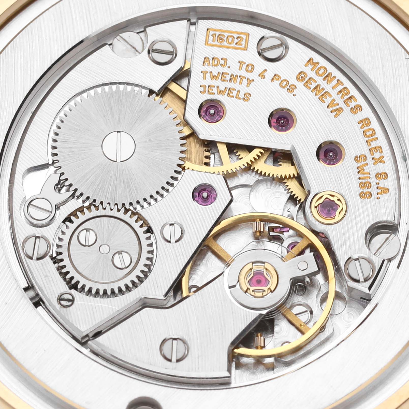 The image shows the intricate internal mechanics of a Rolex Cellini 5116 Men's Yellow Gold White Dial 5116 Men's Yellow Gold White Dial watch, displaying gears and jewels from a close-up angle.