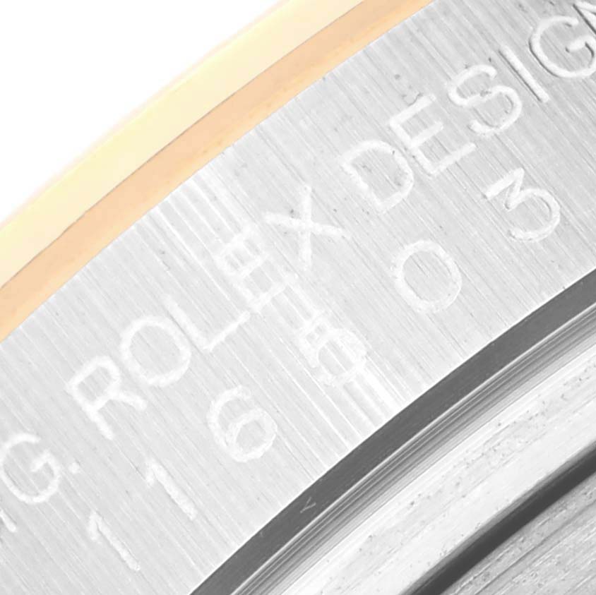 This close-up image shows the inner bezel of a Rolex Daytona 116503 Men's Steel and Gold (two tone) White Dial 116503 Men's Steel and Gold (two tone) White Dial watch, highlighting the "ROLEX DESIG" engraving.