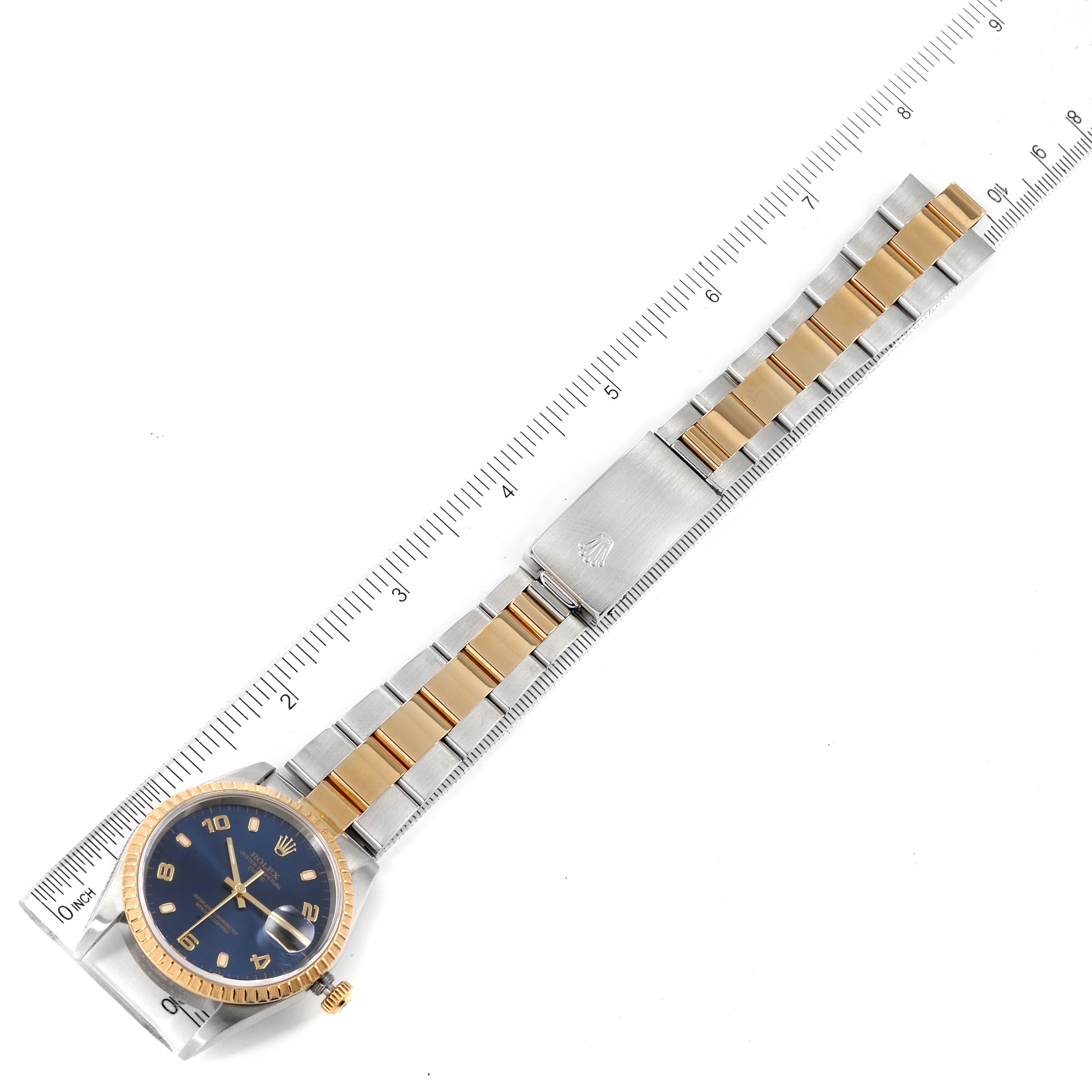 This image shows a Rolex Date 15223 Men's Steel and Gold (two tone) Blue Dial 15223 Men's Steel and Gold (two tone) Blue Dial model watch laid flat with its full band and clasp visible, measured against a ruler.