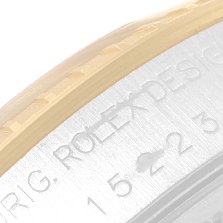 The image shows a close-up of the engraved side of the bezel and part of the casing of a Rolex Date 15223 Men's Steel and Gold (two tone) Blue Dial 15223 Men's Steel and Gold (two tone) Blue Dial model watch.