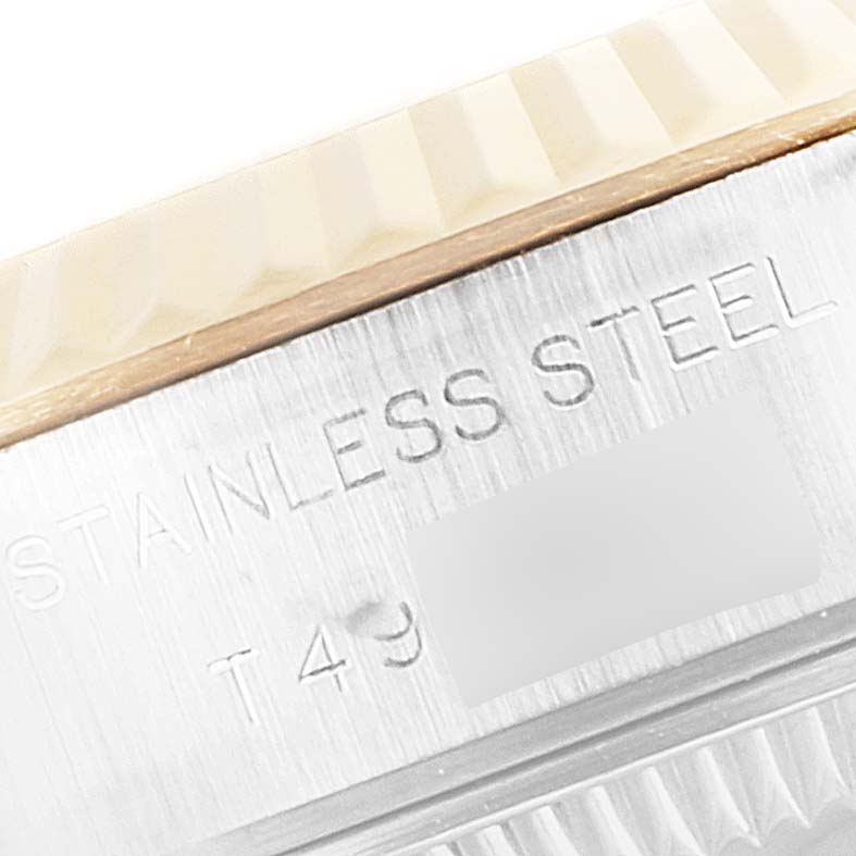 The image shows a close-up of a part of the bezel and an engraved area of the Rolex Datejust 69173 Women's Steel and Gold (two tone) Blue Dial 69173 Women's Steel and Gold (two tone) Blue Dial watch, focusing on materials.