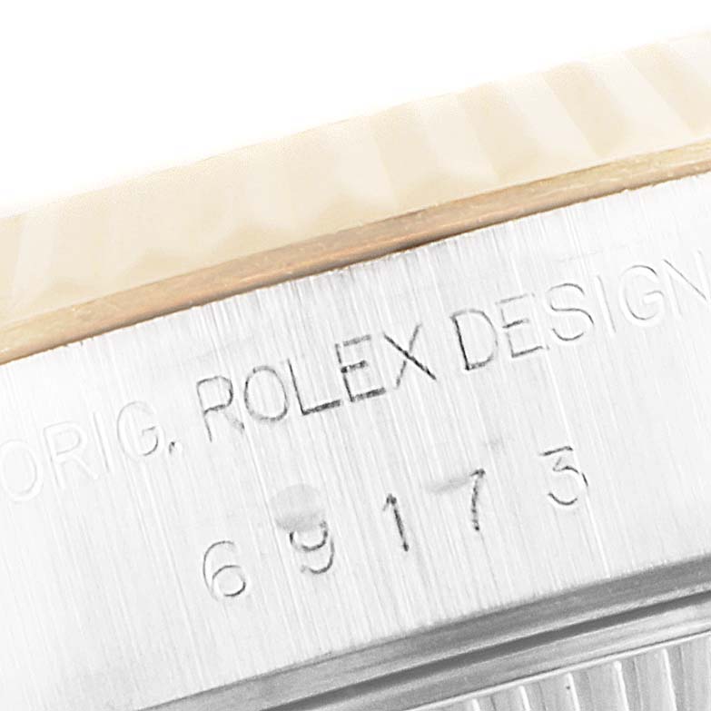 The image shows a close-up of the bezel and engraved case of a Rolex Datejust 69173 Women's Steel and Gold (two tone) Blue Dial 69173 Women's Steel and Gold (two tone) Blue Dial watch.