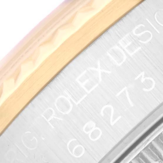 This close-up image shows part of the bezel and the case back engraving of a Rolex Mid-Size 68273 Women
s Steel and Gold (two tone) White Dial 68273 Women
s Steel and Gold (two tone) White Dial watch.