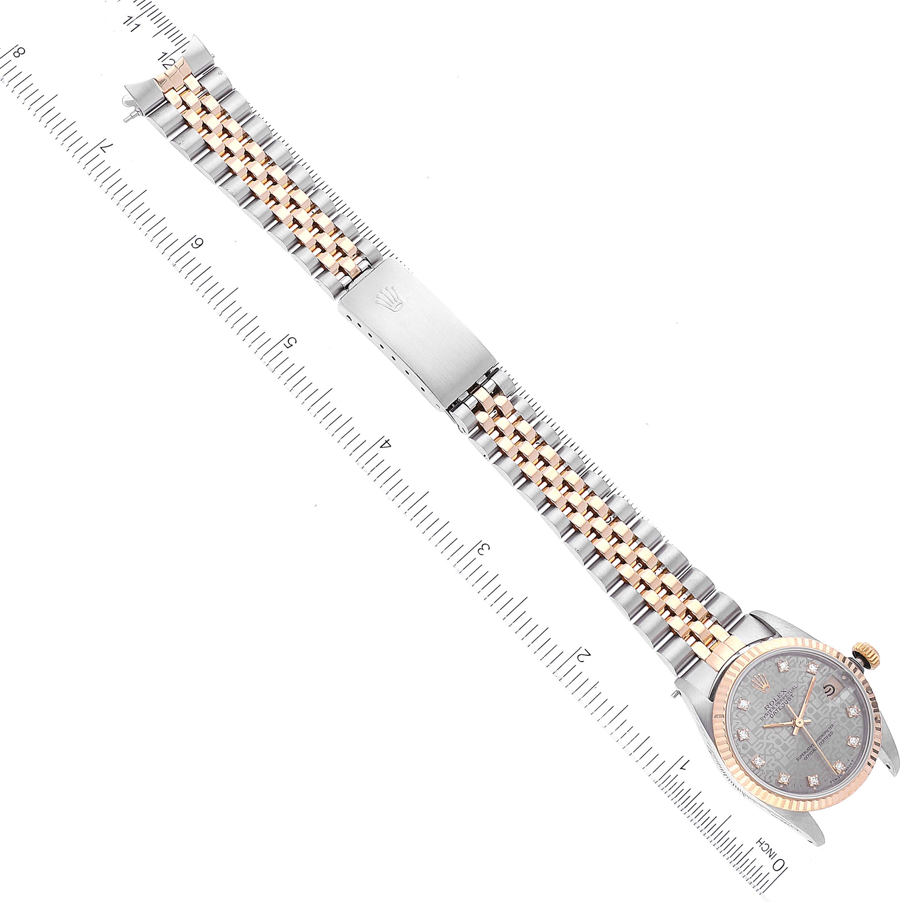 This image showcases the full face and bracelet of a Rolex Mid-Size 68273 Women
s Steel and Gold (two tone) Silver Dial 68273 Women
s Steel and Gold (two tone) Silver Dial model watch, positioned next to a measuring ruler.
