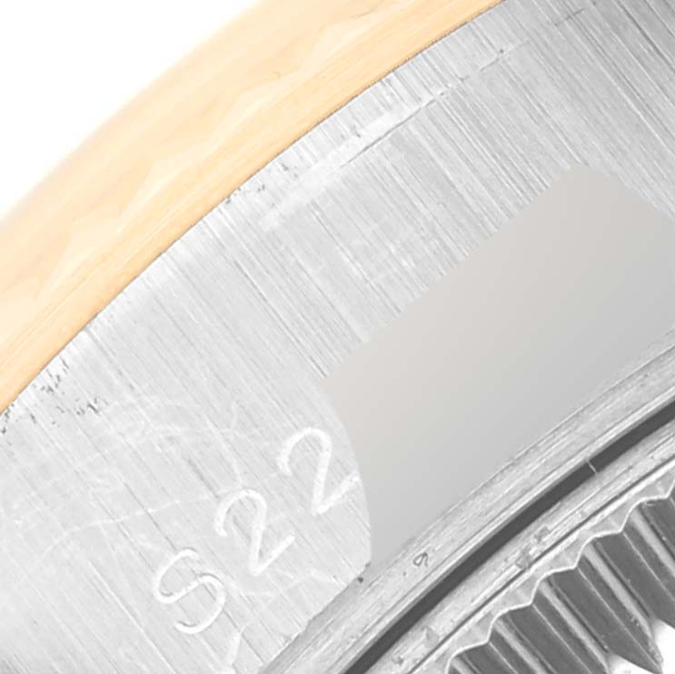 This image shows the edge and partial serial number of a Rolex Datejust 69173G Women's Steel and Gold (two tone) Grey Dial 69173G Women's Steel and Gold (two tone) Grey Dial watch case at a close-up angle.