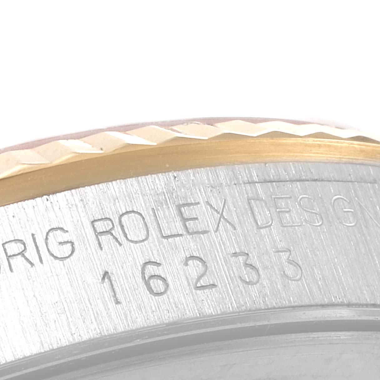 The image shows a close-up of the side view of a Rolex Datejust 16233 Men
s Steel and Gold (two tone) Champagne Dial 16233 Men
s Steel and Gold (two tone) Champagne Dial model, displaying part of the bezel and engraved serial numbers.