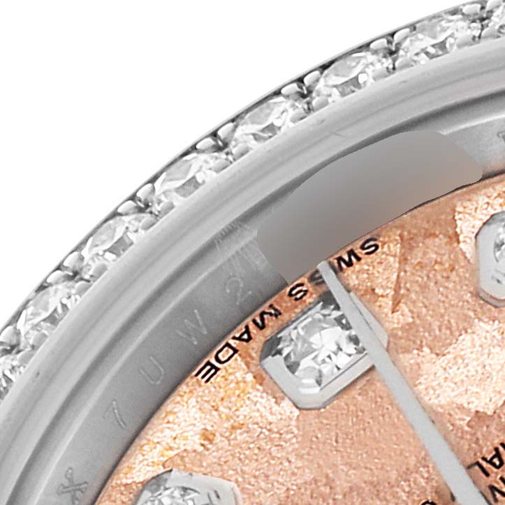 This close-up image shows the bezel and part of the dial of a Rolex Datejust 179384 Women's Stainless Steel Pink Dial 179384 Women's Stainless Steel Pink Dial watch.