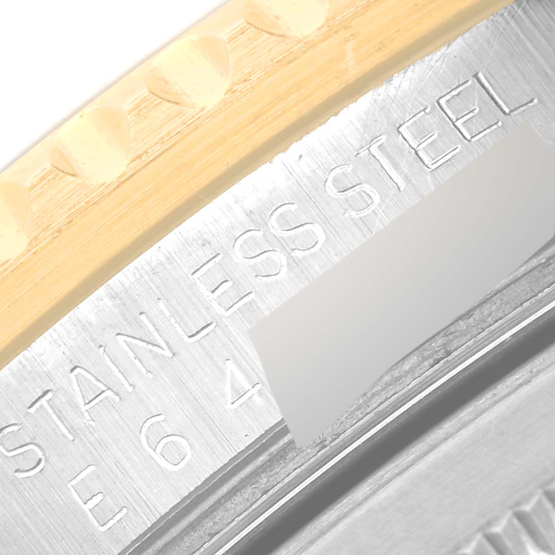 This is a close-up image showing the engraved "STAINLESS STEEL" text on the GMT-Master model by Rolex.