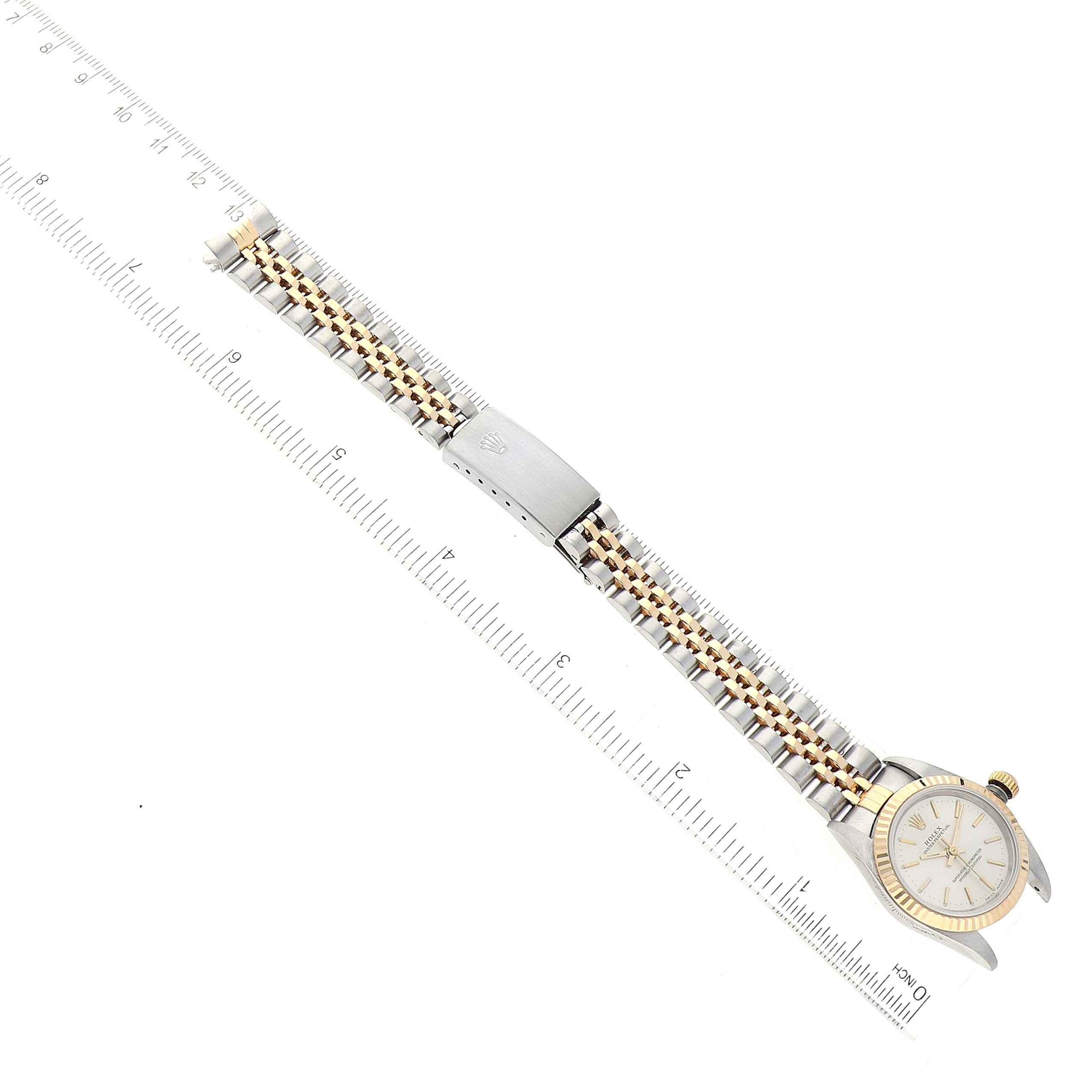 The image shows a Rolex Datejust 76193 Women's Steel and Gold (two tone) Silver Dial 76193 Women's Steel and Gold (two tone) Silver Dial watch from an aerial view, displaying its face and entire band alongside a ruler.