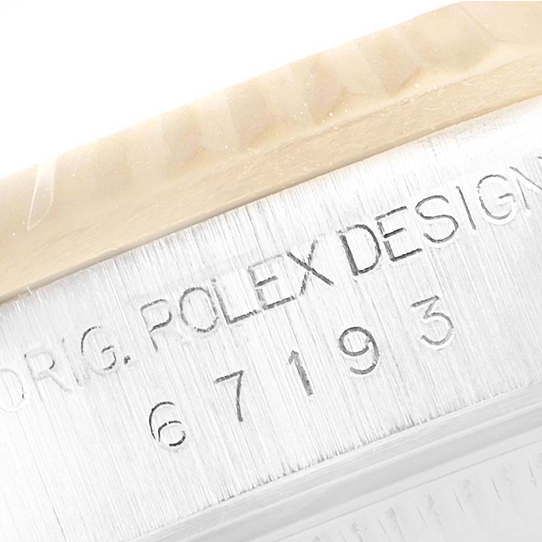 This image shows an angled close-up of the Rolex Oyster Perpetual 67193 Women's Steel and Gold (two tone) Silver Dial 67193 Women's Steel and Gold (two tone) Silver Dial's case side, displaying its engraved model number "67193."