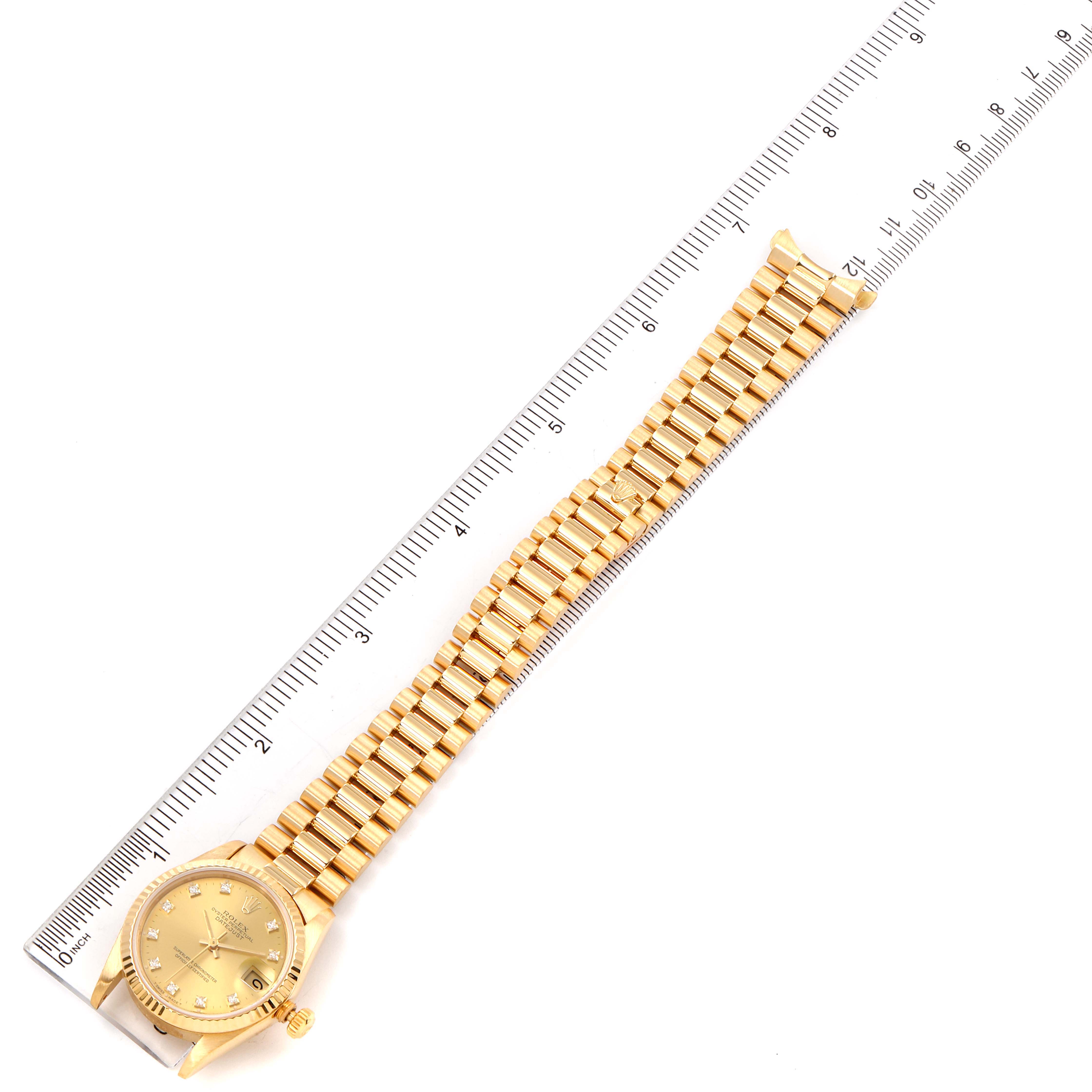 The image shows a Rolex President 68278 Women's Yellow Gold Champagne Dial 68278 Women's Yellow Gold Champagne Dial model watch laid flat with its bracelet alongside a ruler for size reference.