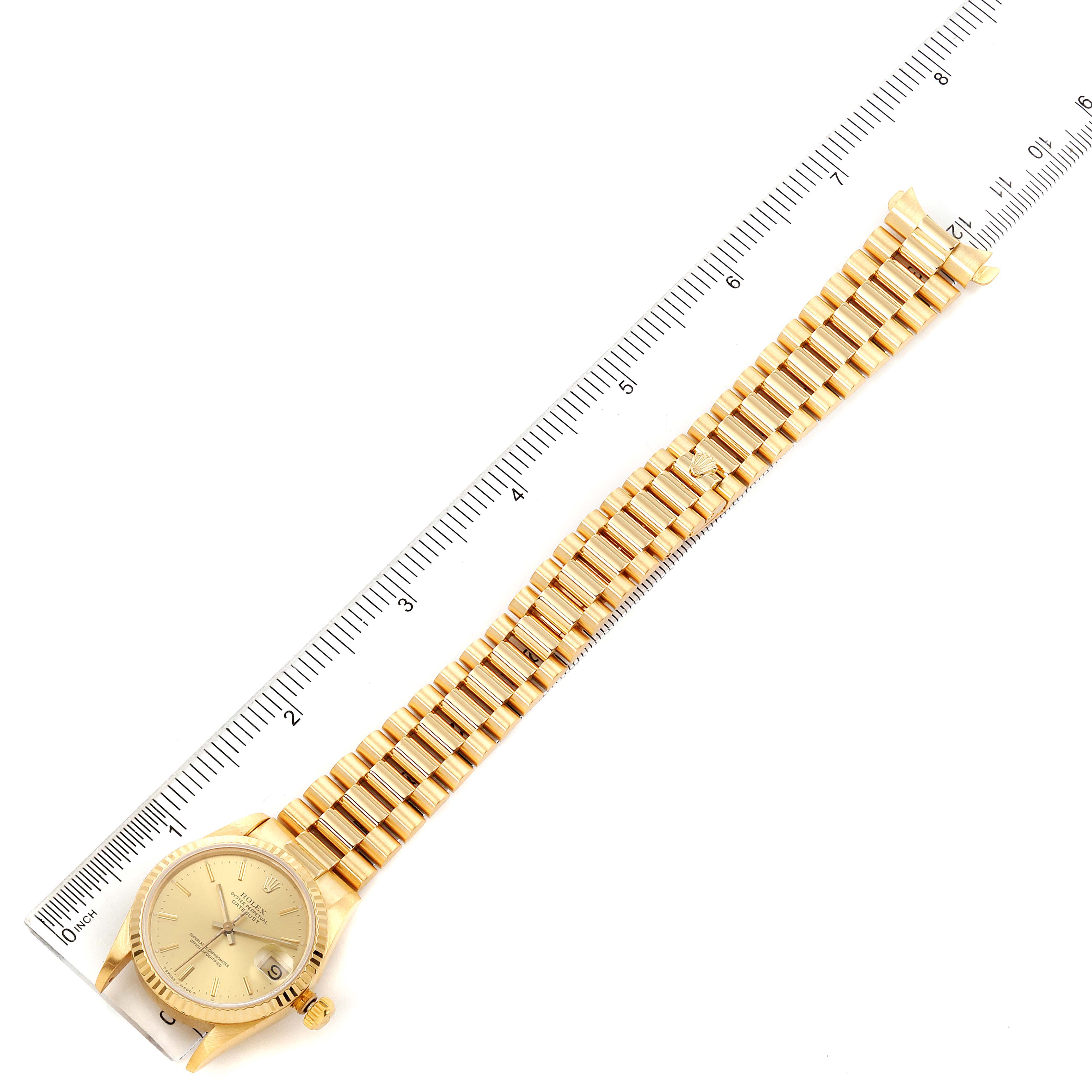 The image shows a top view of a Rolex President 68278 Women
s Yellow Gold Champagne Dial 68278 Women
s Yellow Gold Champagne Dial model watch, highlighting its face, bracelet, and a ruler for scale.