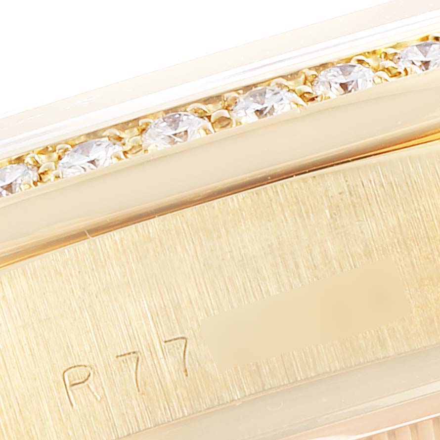This close-up image of a Rolex President 18048 Men
s Yellow Gold Champagne Dial 18048 Men
s Yellow Gold Champagne Dial model shows the edge of the bezel adorned with diamonds and part of the band with engraved markings.
