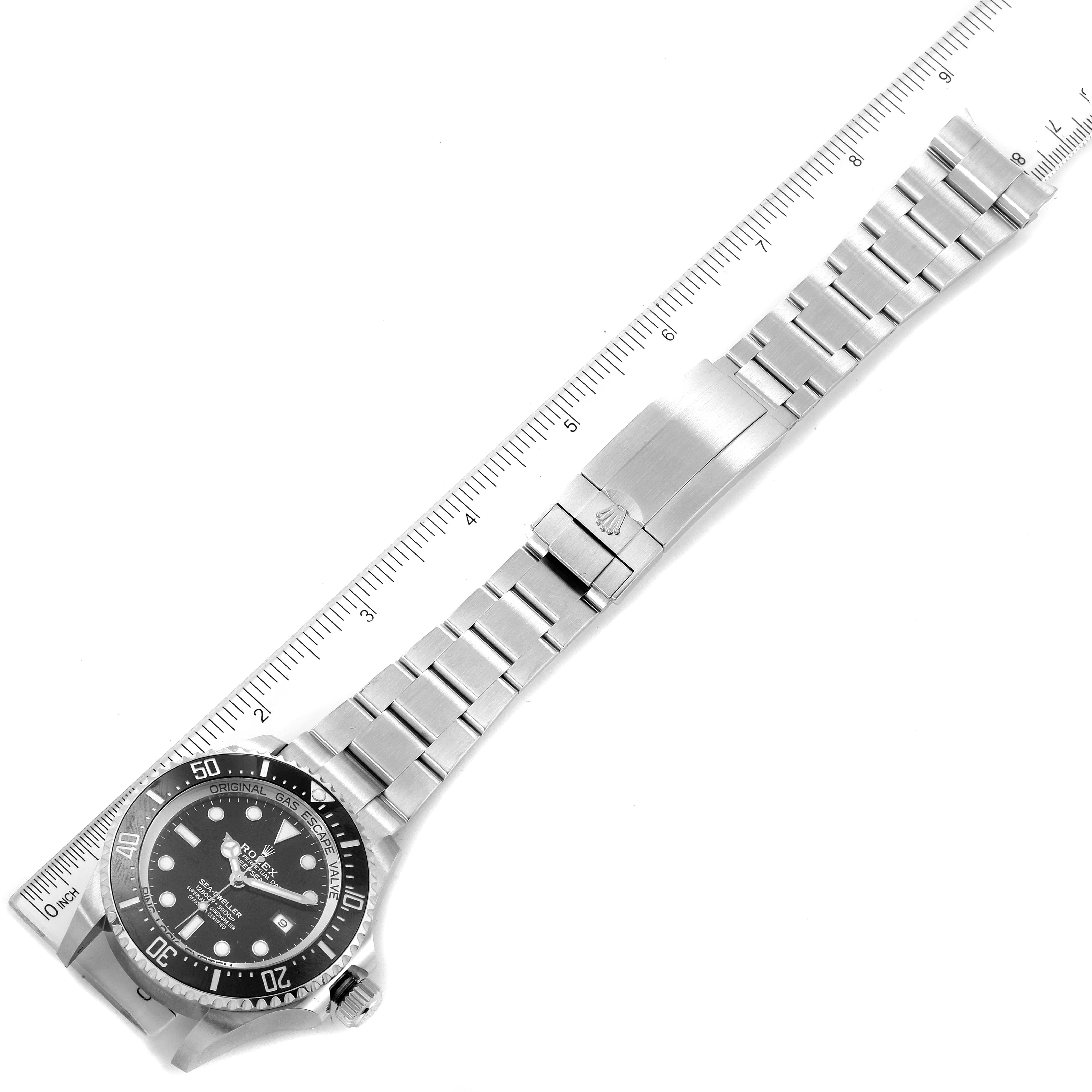 The image shows a Rolex Sea-Dweller 126660 Men
s Stainless Steel Black Dial 126660 Men
s Stainless Steel Black Dial watch displayed flat along a measuring scale, highlighting the face and bracelet.