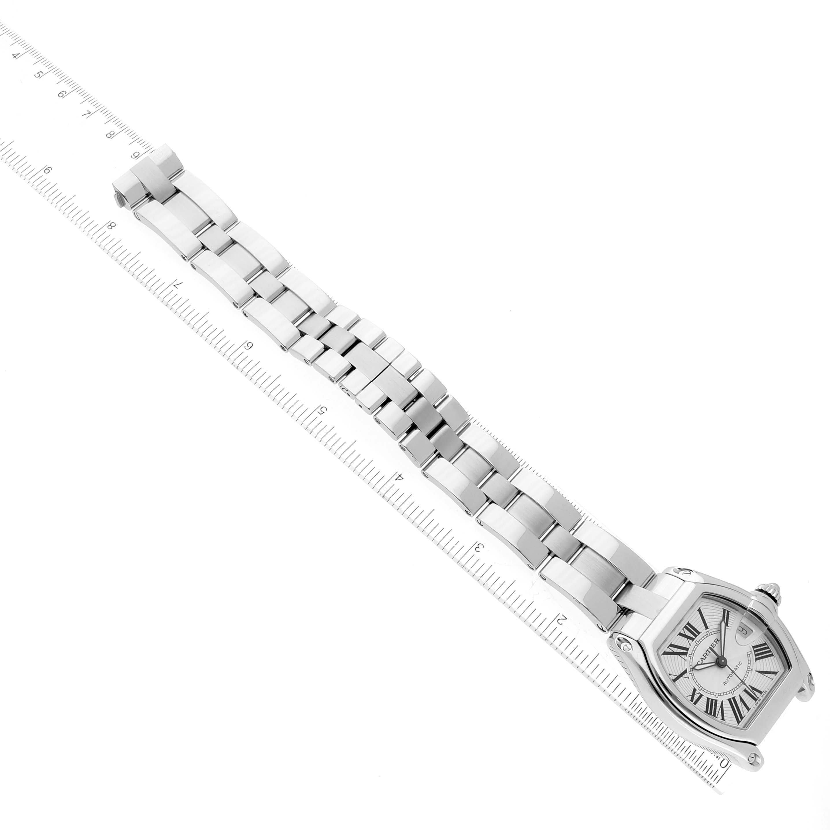 The image shows a top-down view of a Cartier Roadster W62025V3 Men's Stainless Steel Silver Dial W62025V3 Men's Stainless Steel Silver Dial watch, highlighting the face, bracelet, and a ruler for scale.