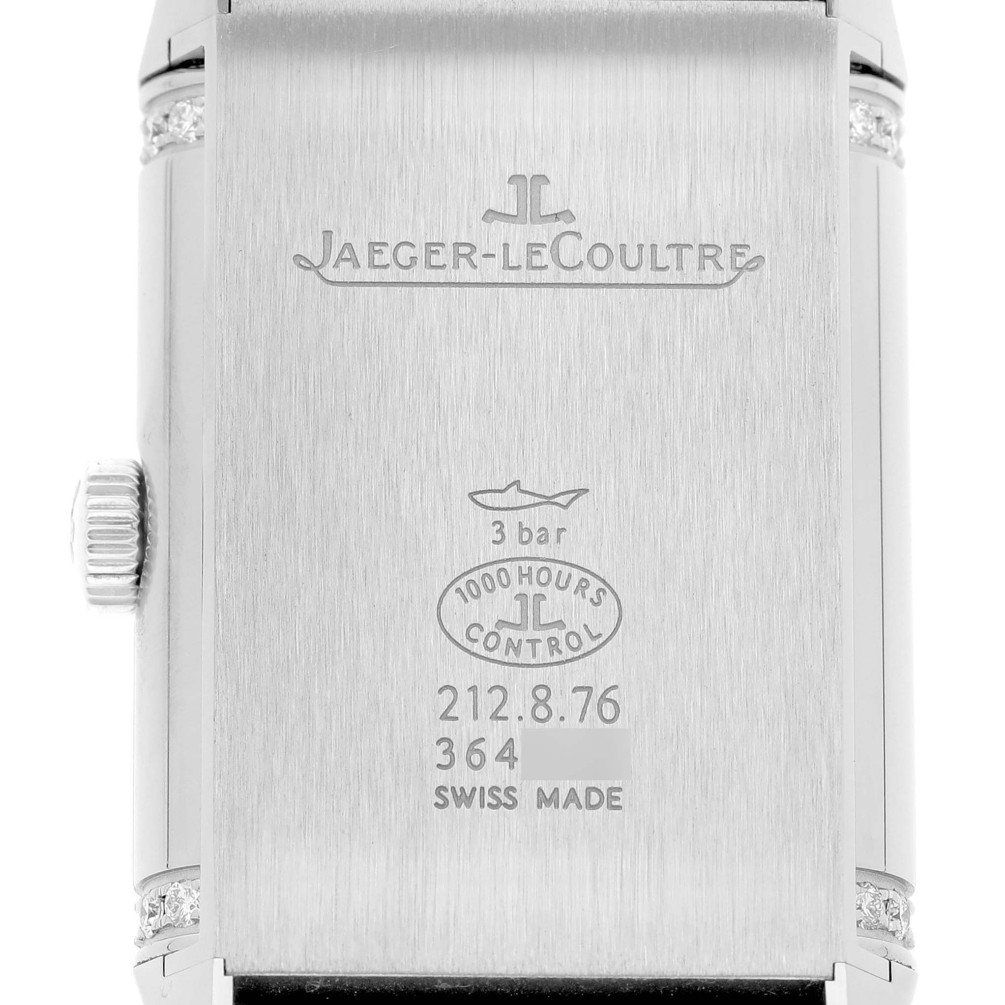 The image shows the back of the Jaeger-LeCoultre Reverso watch with inscriptions and the crown on the left side.