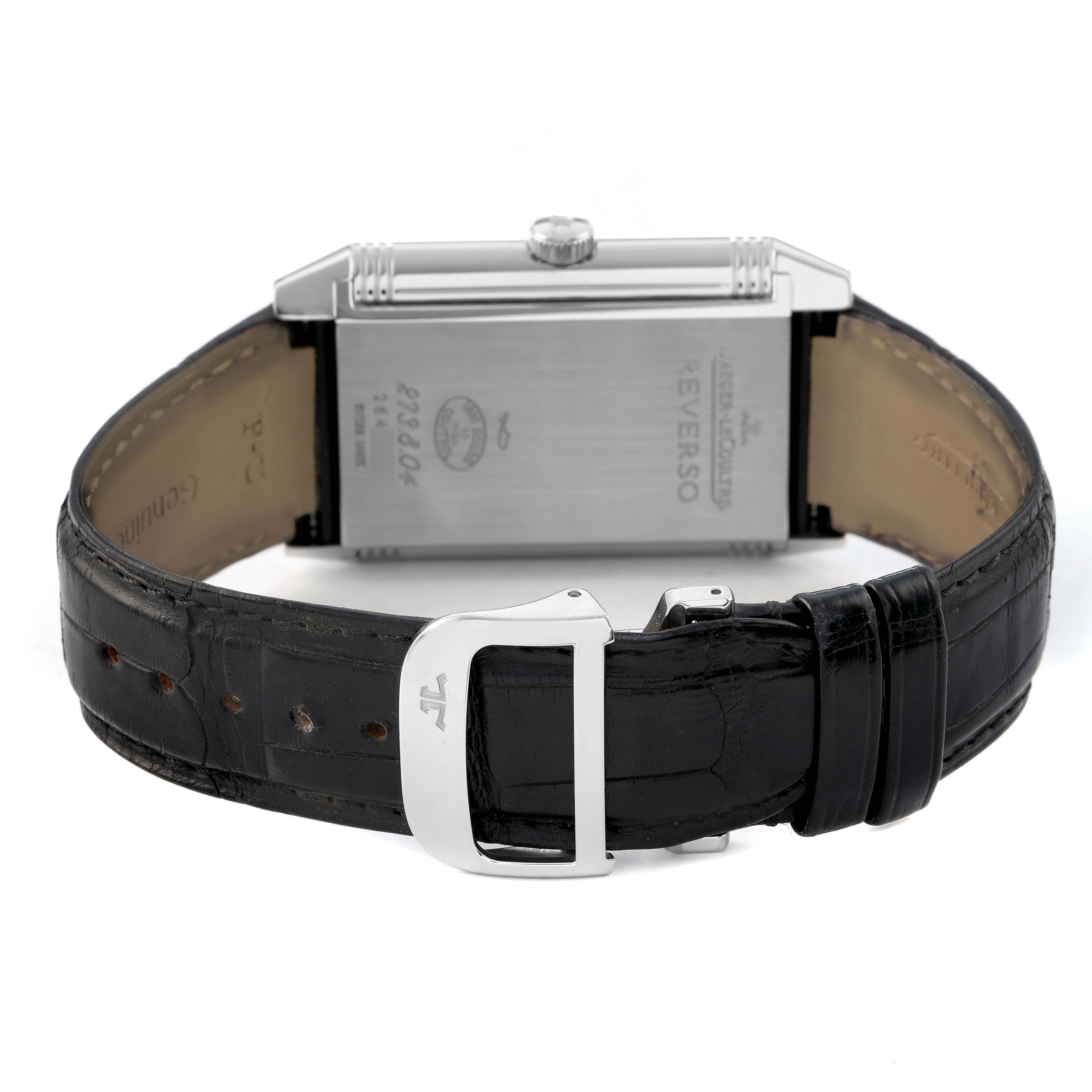 The Jaeger-LeCoultre Reverso watch is shown from the back, displaying the case back and black leather strap with a buckle.