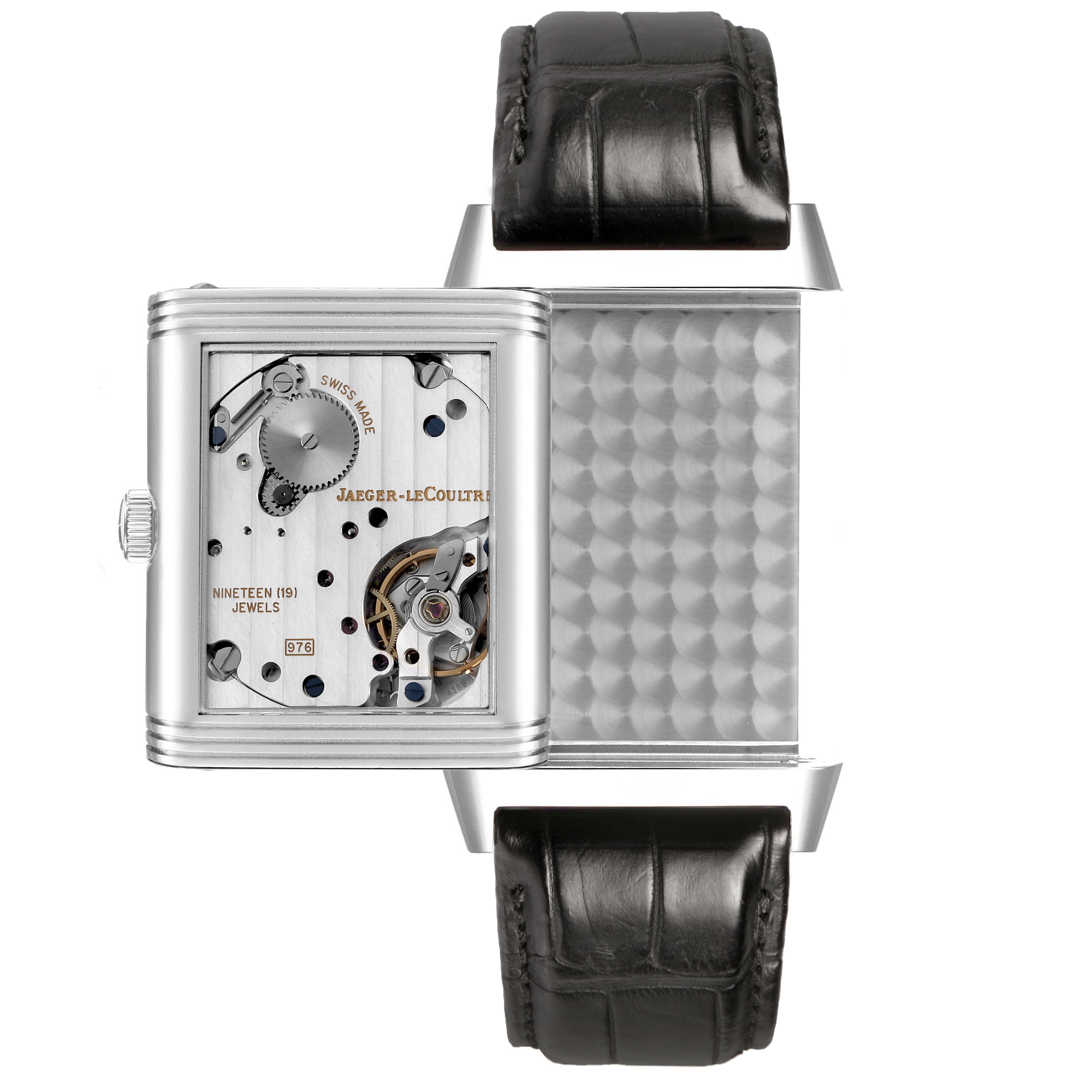The Jaeger-LeCoultre Reverso watch is shown with its case swiveled, revealing the movement and back panel details.