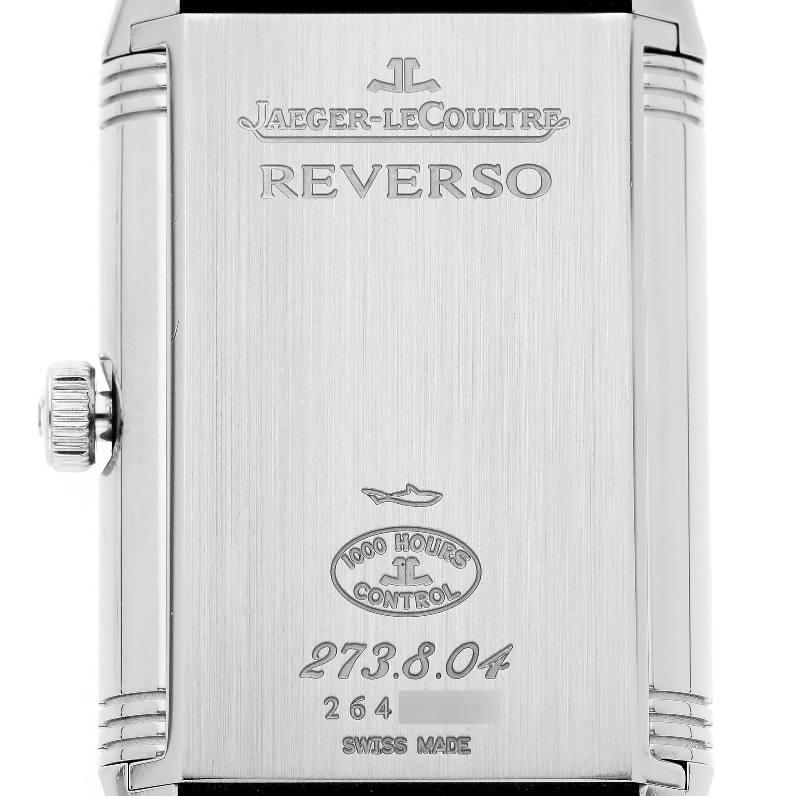 The image shows the engraved backside of a Jaeger-LeCoultre Reverso watch, including the crown on the side.