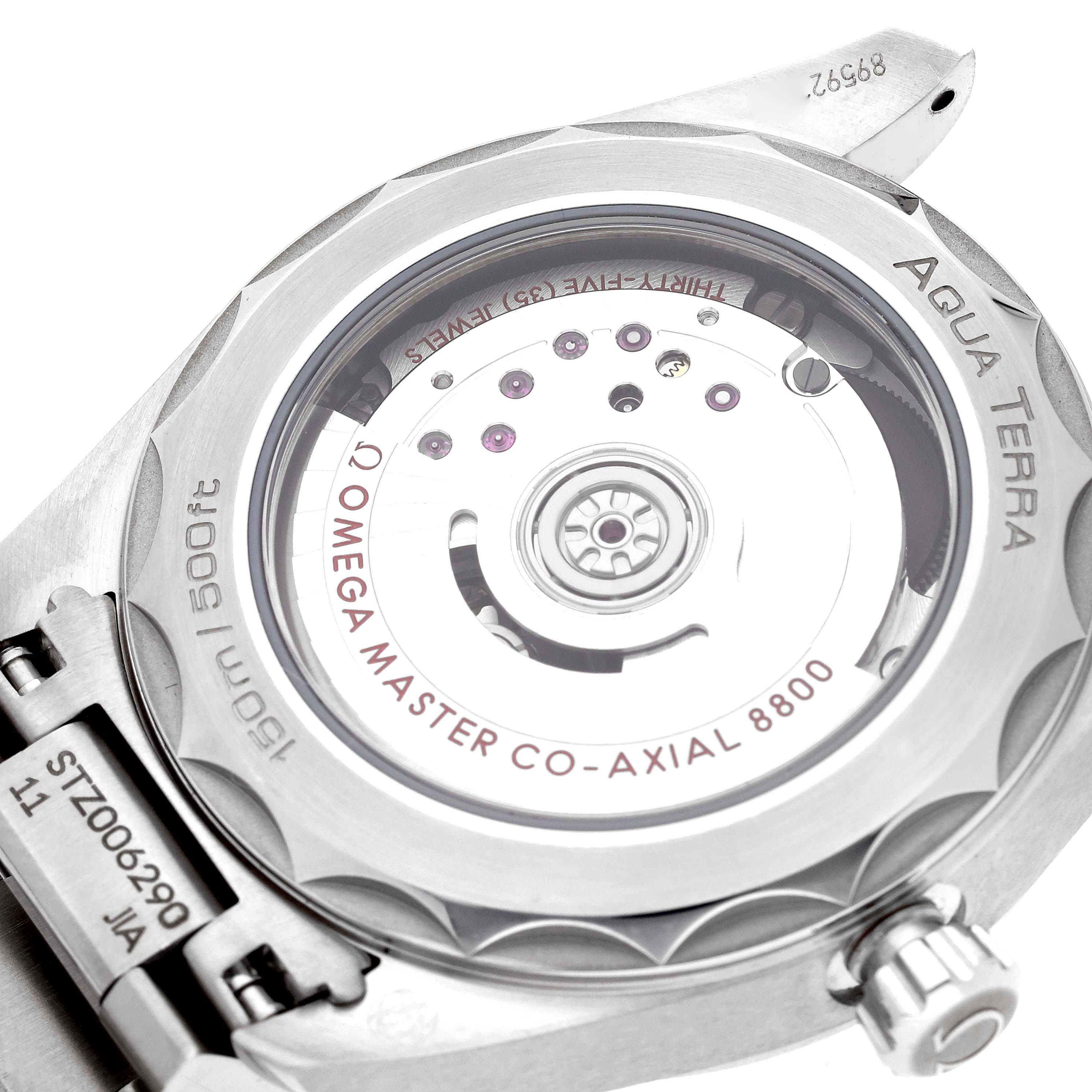 The image shows the back of the Omega Aqua Terra 220.10.38.20.03.001 Men's Stainless Steel Blue Dial 220.10.38.20.03.001 Men's Stainless Steel Blue Dial watch, highlighting its movement and metal bracelet connection.