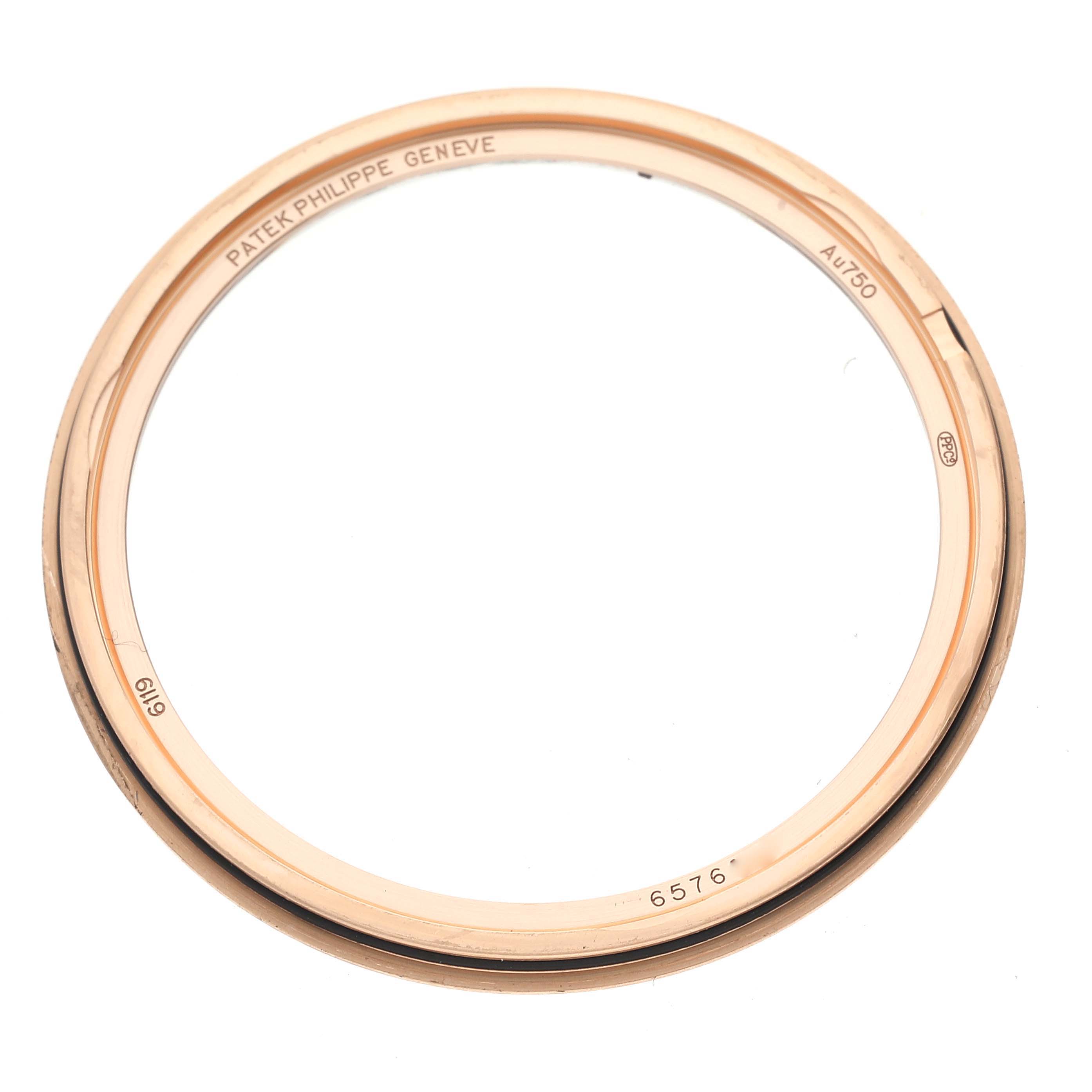 The image shows a gold watch bezel from a Patek Philippe Calatrava 6119R-001 Men's Rose Gold Silver Dial 6119R-001 Men's Rose Gold Silver Dial model, viewed from a top-down angle.