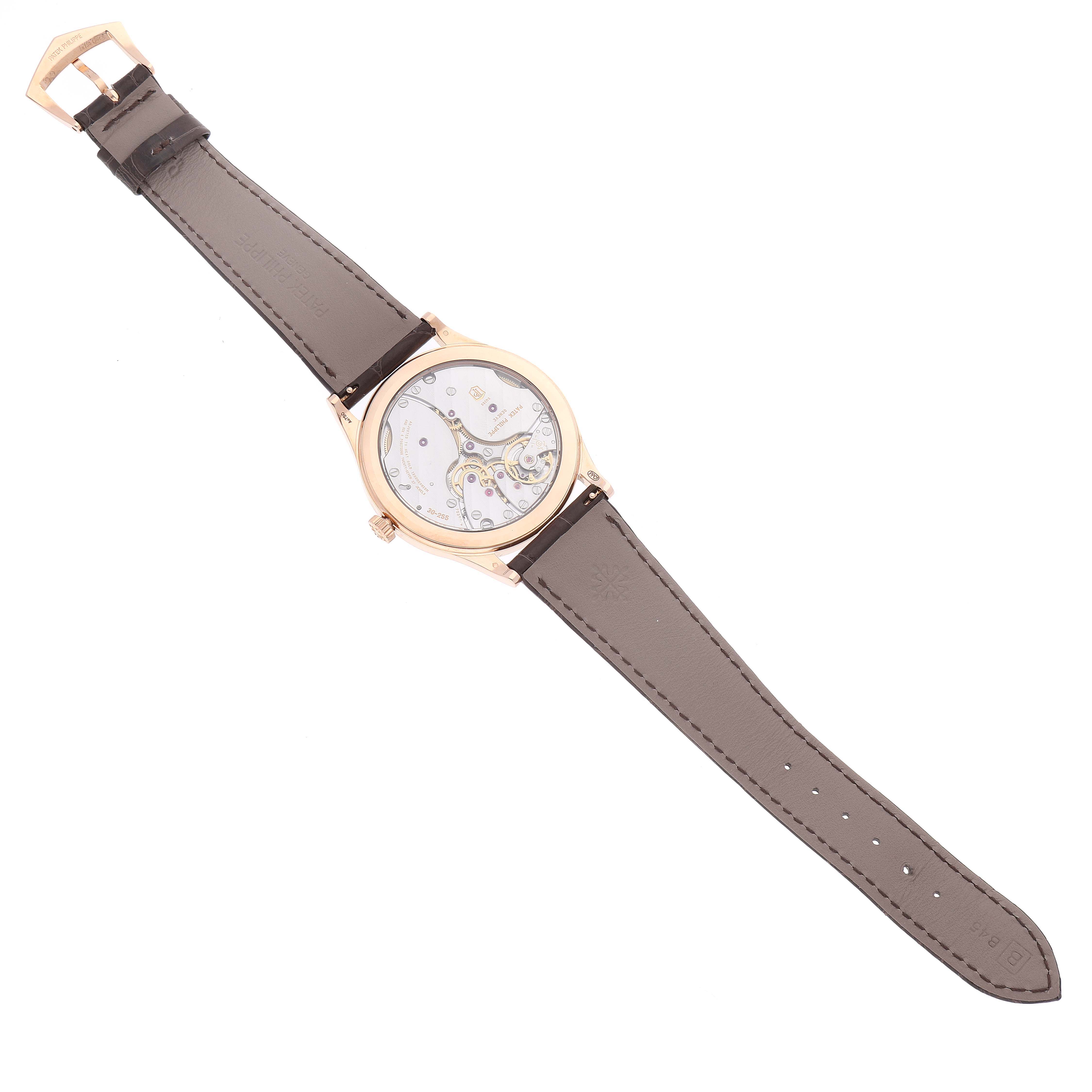 This image shows the back view of a Patek Philippe Calatrava 6119R-001 Men's Rose Gold Silver Dial 6119R-001 Men's Rose Gold Silver Dial watch, revealing its movement and black leather strap.