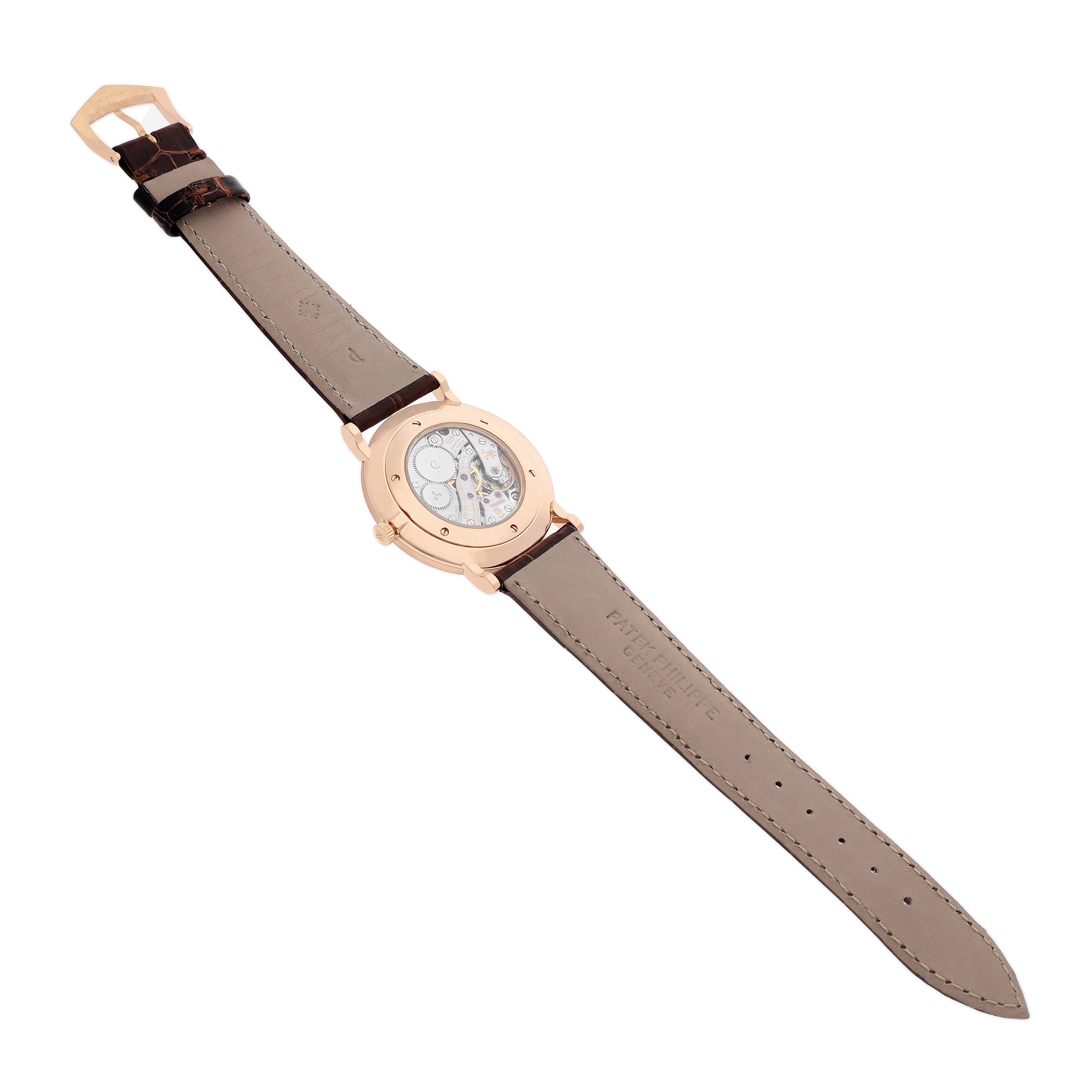 The Patek Philippe Calatrava 5119R Men's Yellow Gold White Dial watch is shown from the back angle, displaying the movement and leather strap.