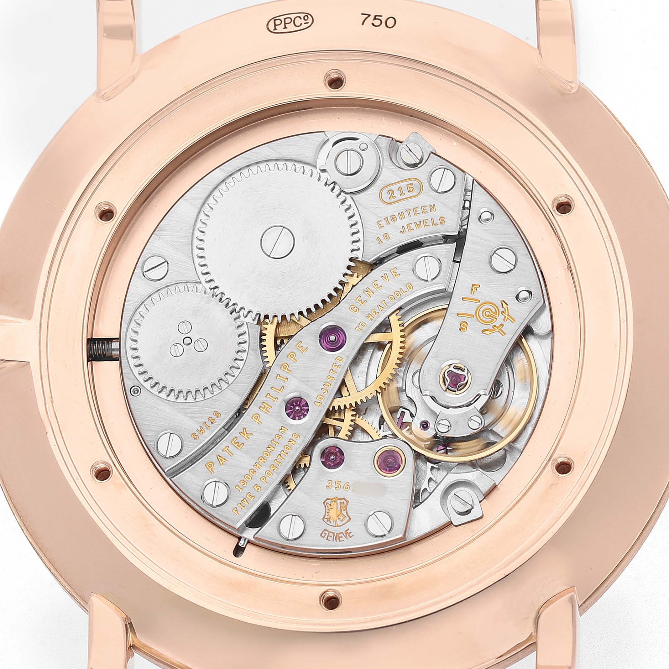 The image shows the movement of a Patek Philippe Calatrava 5119R Men's Yellow Gold White Dial watch from the back, highlighting gears and jewels.
