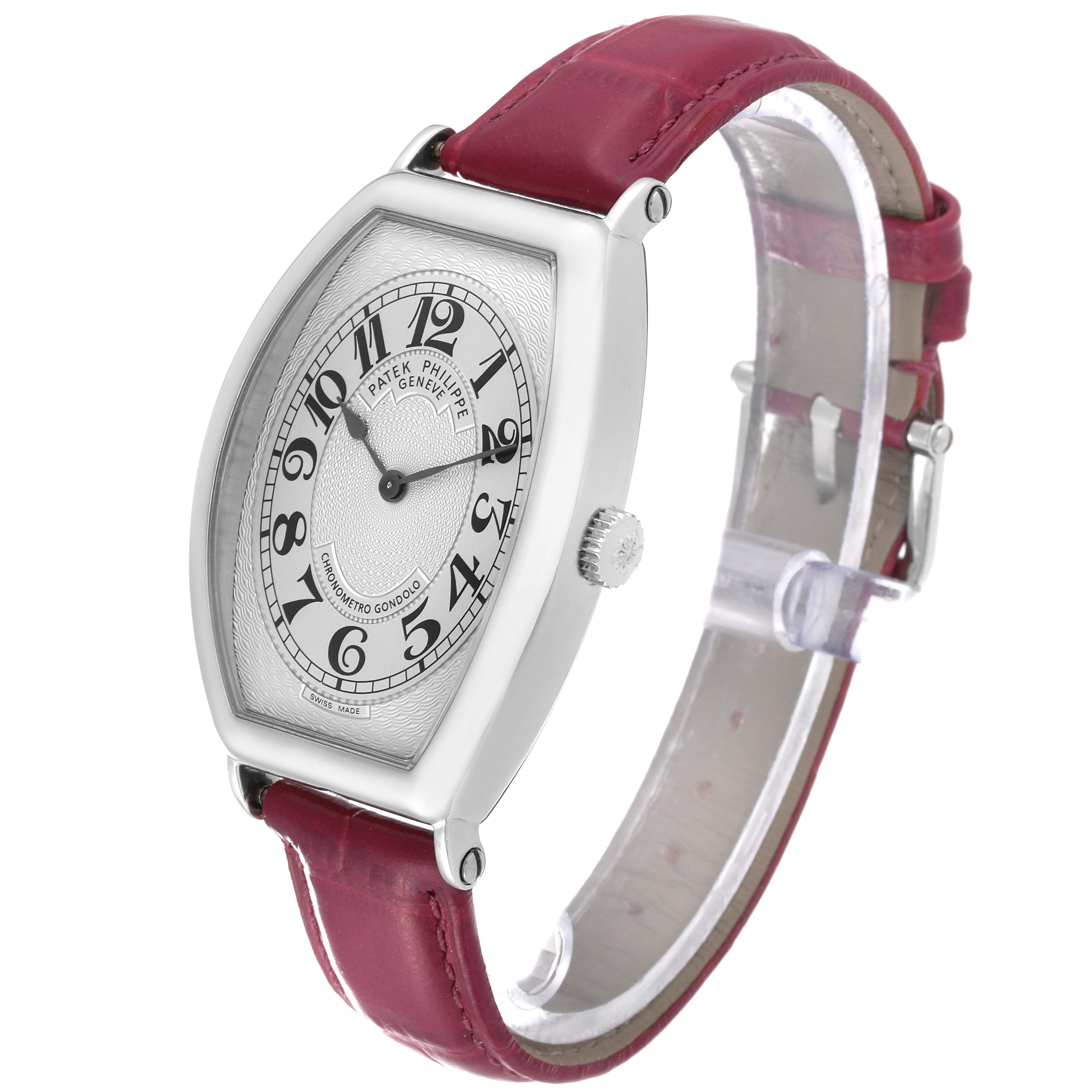 The image shows a Patek Philippe Gondolo 5098P Men's Platinum Silver Dial 5098P Men's Platinum Silver Dial watch angled from the front and side, featuring its red strap and silver dial.