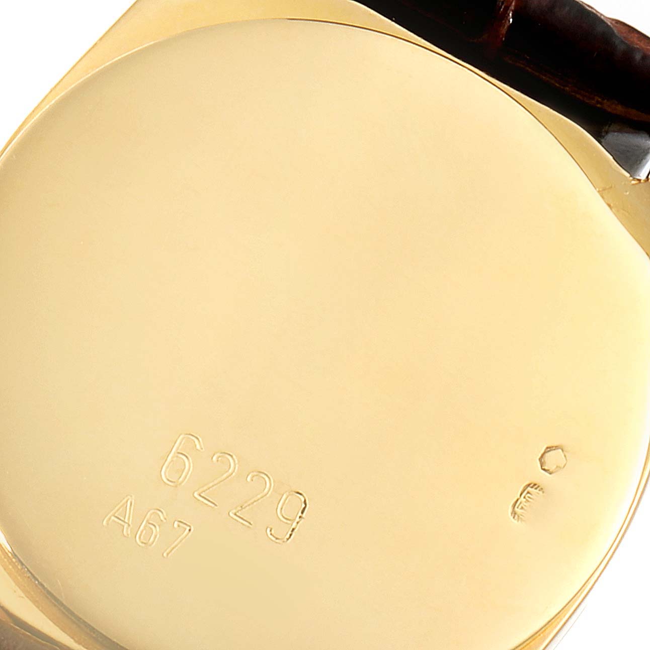 The image shows the back case of a Rolex Cellini 6229 Women's Yellow Gold Black Dial 6229 Women's Yellow Gold Black Dial watch with model number 6229, featuring engravings and part of the strap.