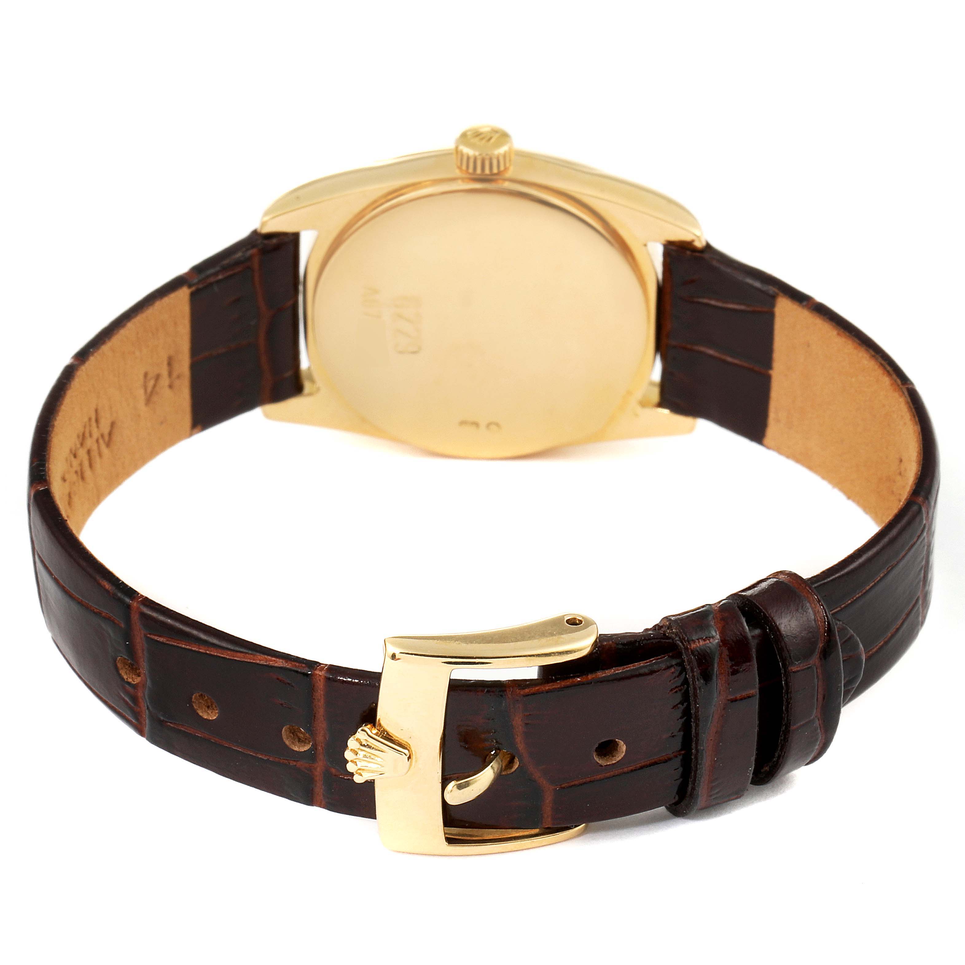 This image shows the back of the Rolex Cellini 6229 Women's Yellow Gold Black Dial 6229 Women's Yellow Gold Black Dial watch, highlighting the gold case, crown, and brown leather strap with a gold buckle.