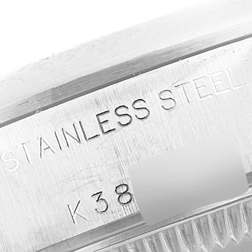 This close-up image of a Rolex Date 79160 Women's Stainless Steel Silver Dial 79160 Women's Stainless Steel Silver Dial model watch shows the side of the case with "STAINLESS STEEL" and part of the serial number engraved.
