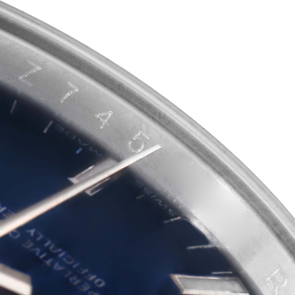 The image shows a close-up of the dial and partially the bezel of a Rolex Date 115200 Men's Stainless Steel Blue Dial 115200 Men's Stainless Steel Blue Dial model watch, focusing on the 4 and 5 markers.